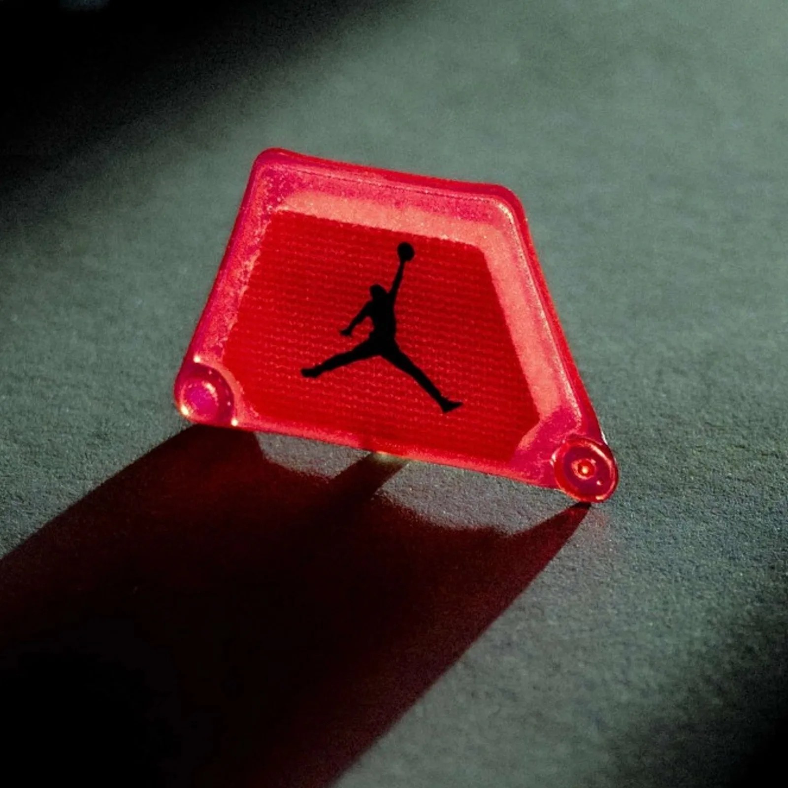 A close-up view of the Jordan Brand Air Rev&rsquo;s moveable Air Zoom, which appeared to be a clear reddish pink piece of plastic with Jordan Brand's iconic Jumpman logo in black at the center 