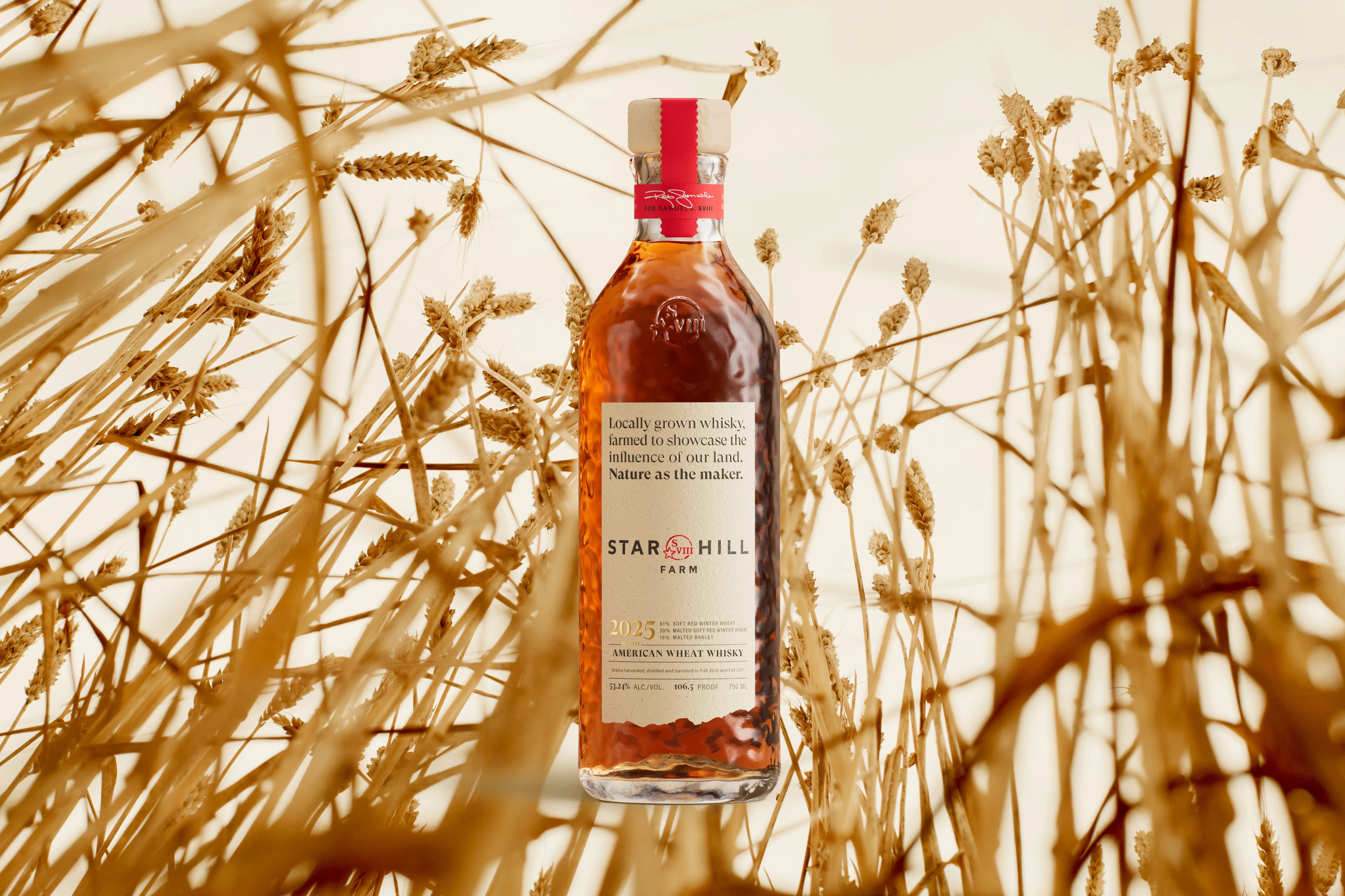 A bottle of Star Hill Farm Whisky shown against a background of tall wheat.