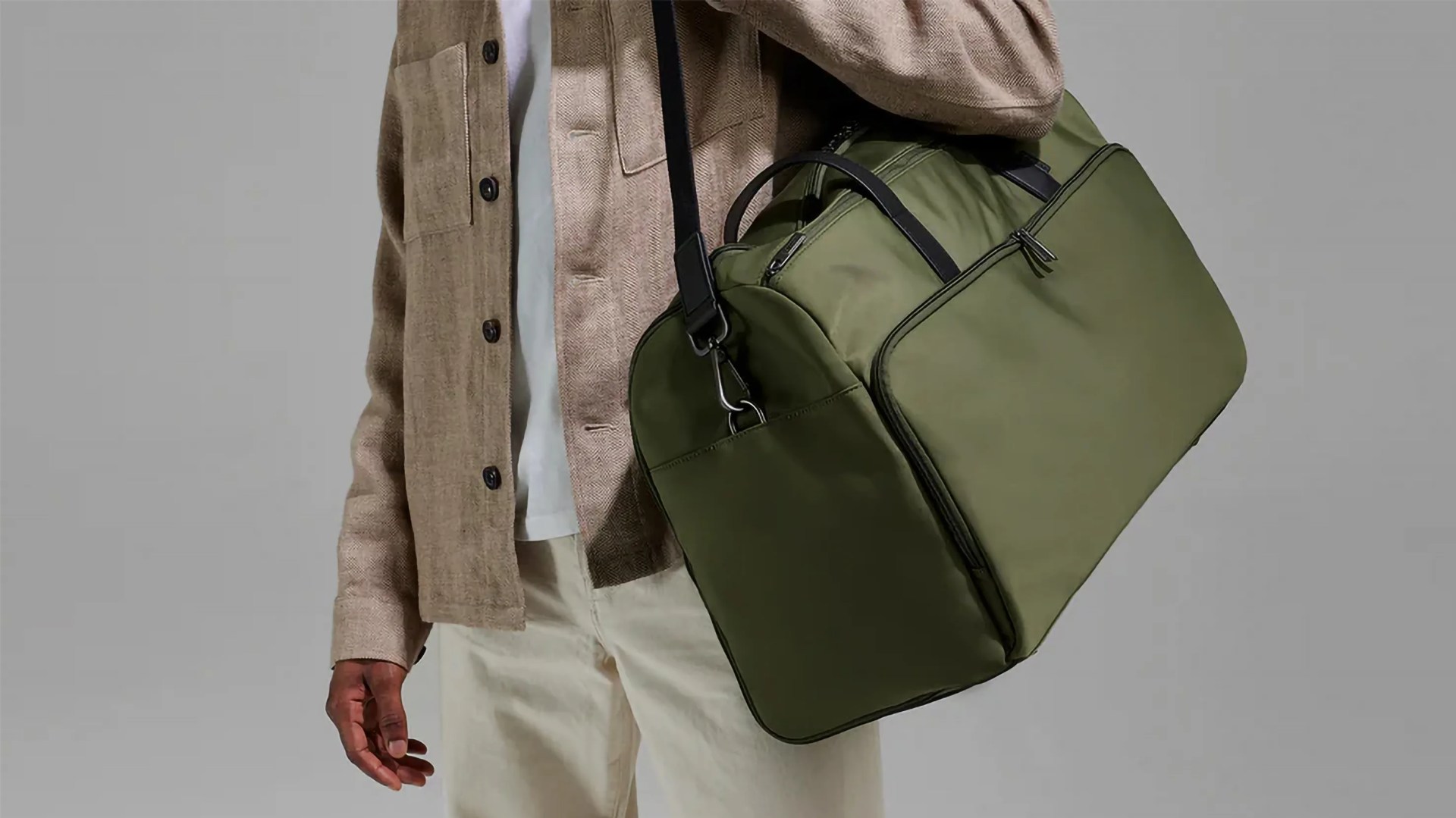 man carrying green duffle bag
