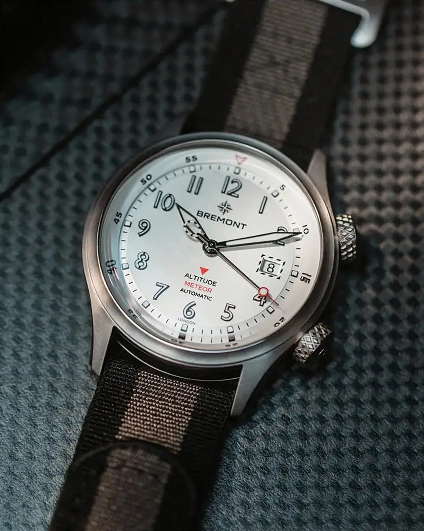 a white pilots watch with a nylon nato strap