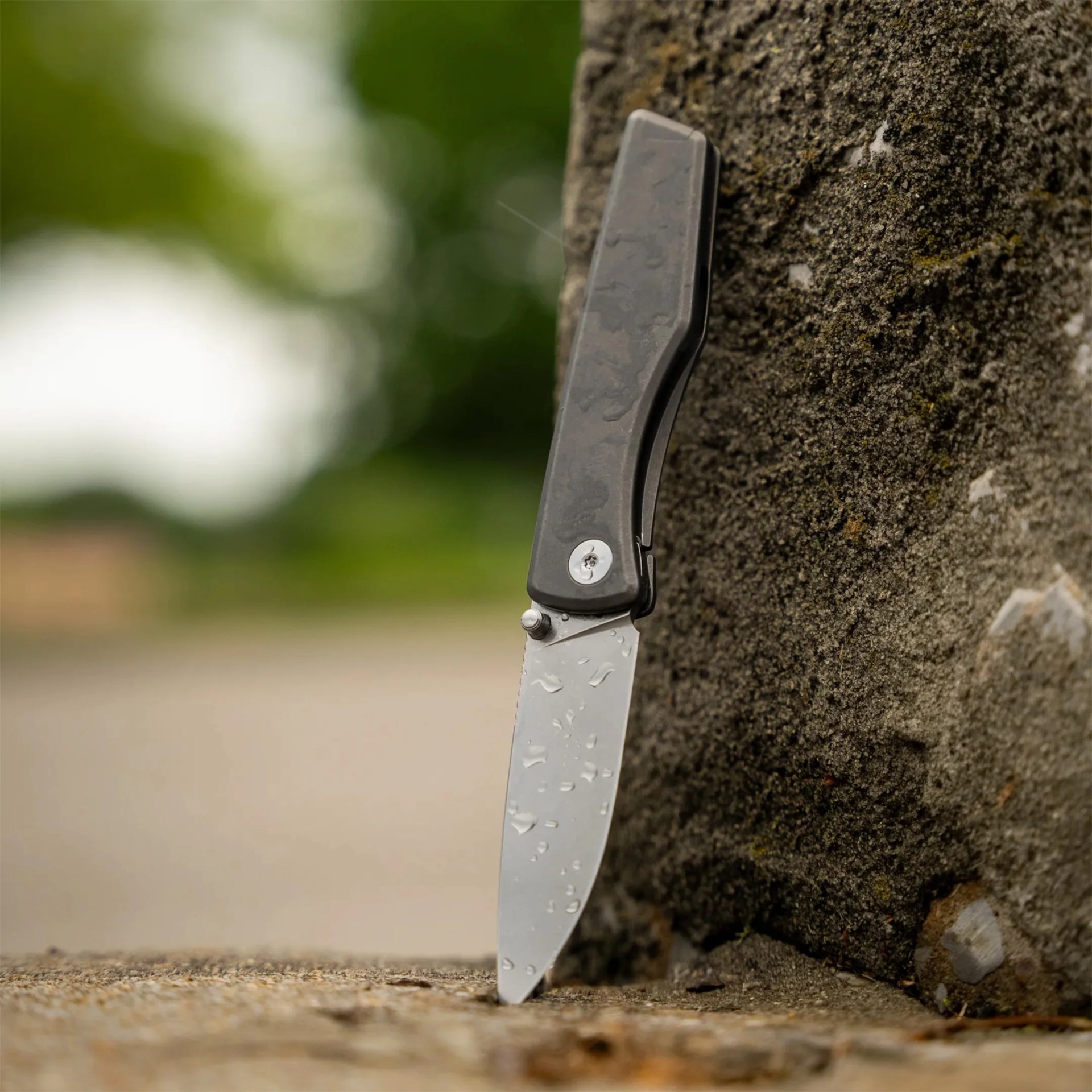 Big Idea Design Overlook EDC Knife outside against stone wall