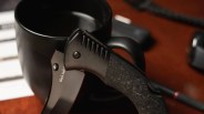 Cold Steel Black Sable EDC Knife on coffee mug on wood desk with watch, glasses, pen, etc. closeup
