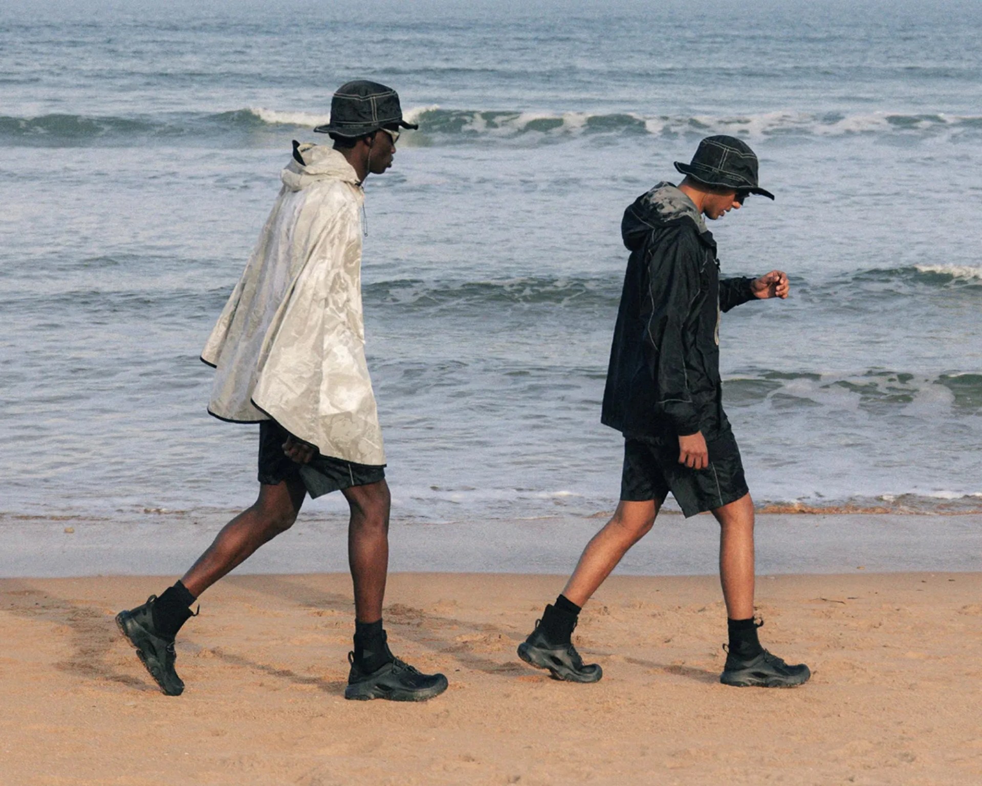 Two people wearing End x and Wander x Crocs Trailbreak sneakers on beach
