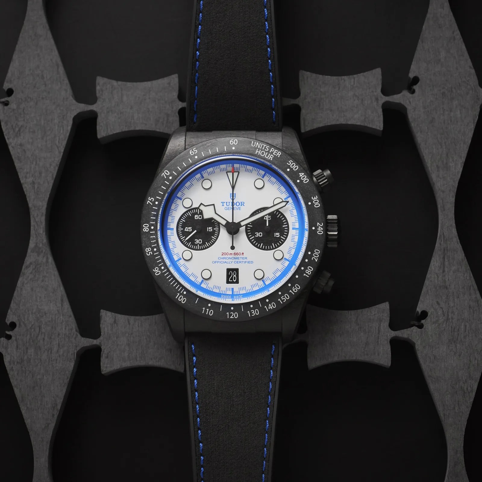 Tudor Black Bay Chrono "Carbon 25" watch shown flat on a grey and black patterned background