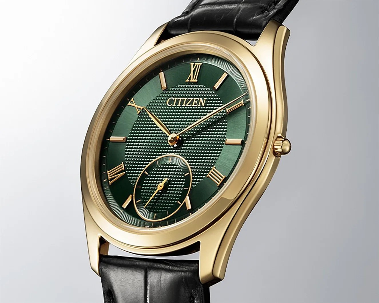 a gold Citizen dress watch with a green dial