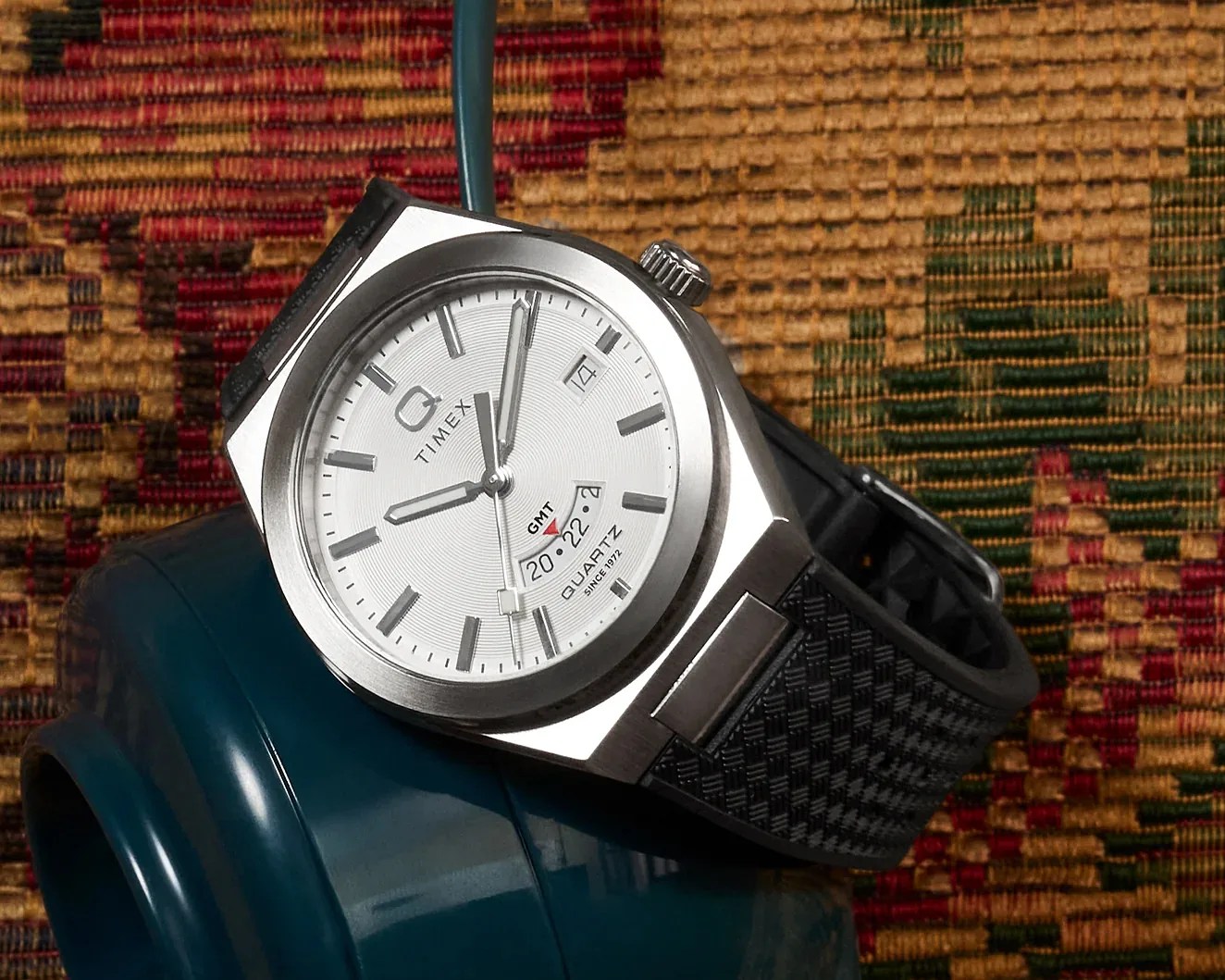 a Q Timex GMT watch laying on a phone