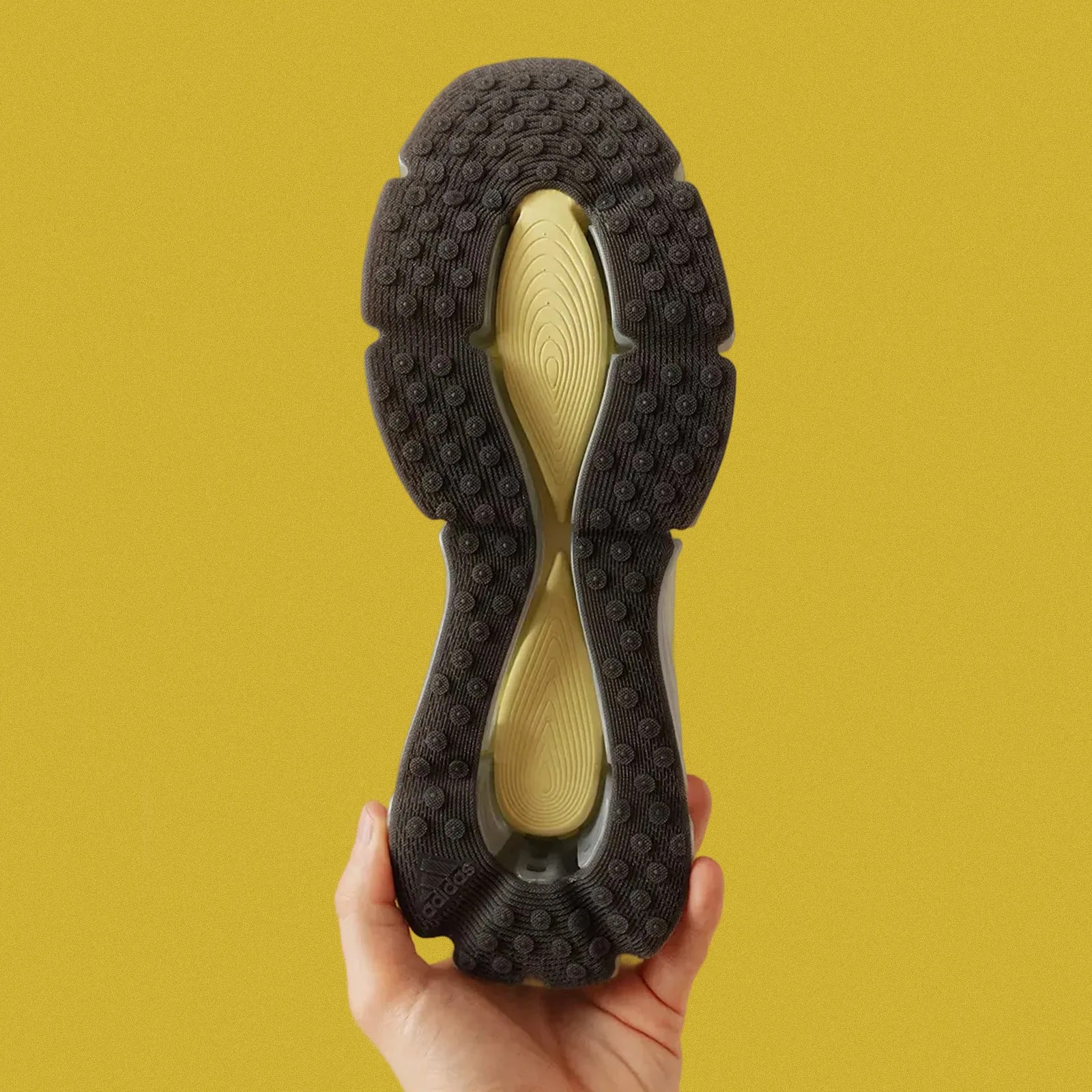 The sole of a single Adidas Megarise AG sneaker shown held up by a hand