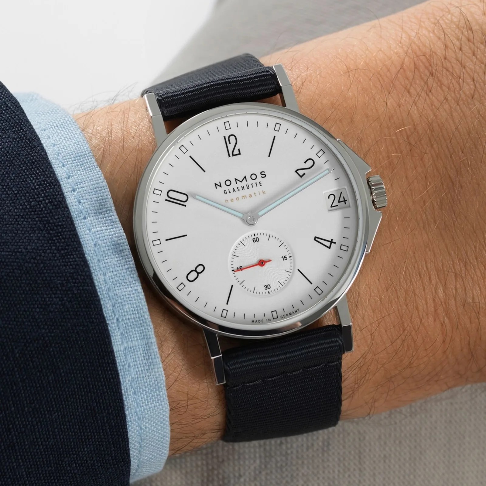 close-up of the wrist of a man wearing the Nomos Glashütte Ahoi Neomatik 38 Date in White on his wrist.