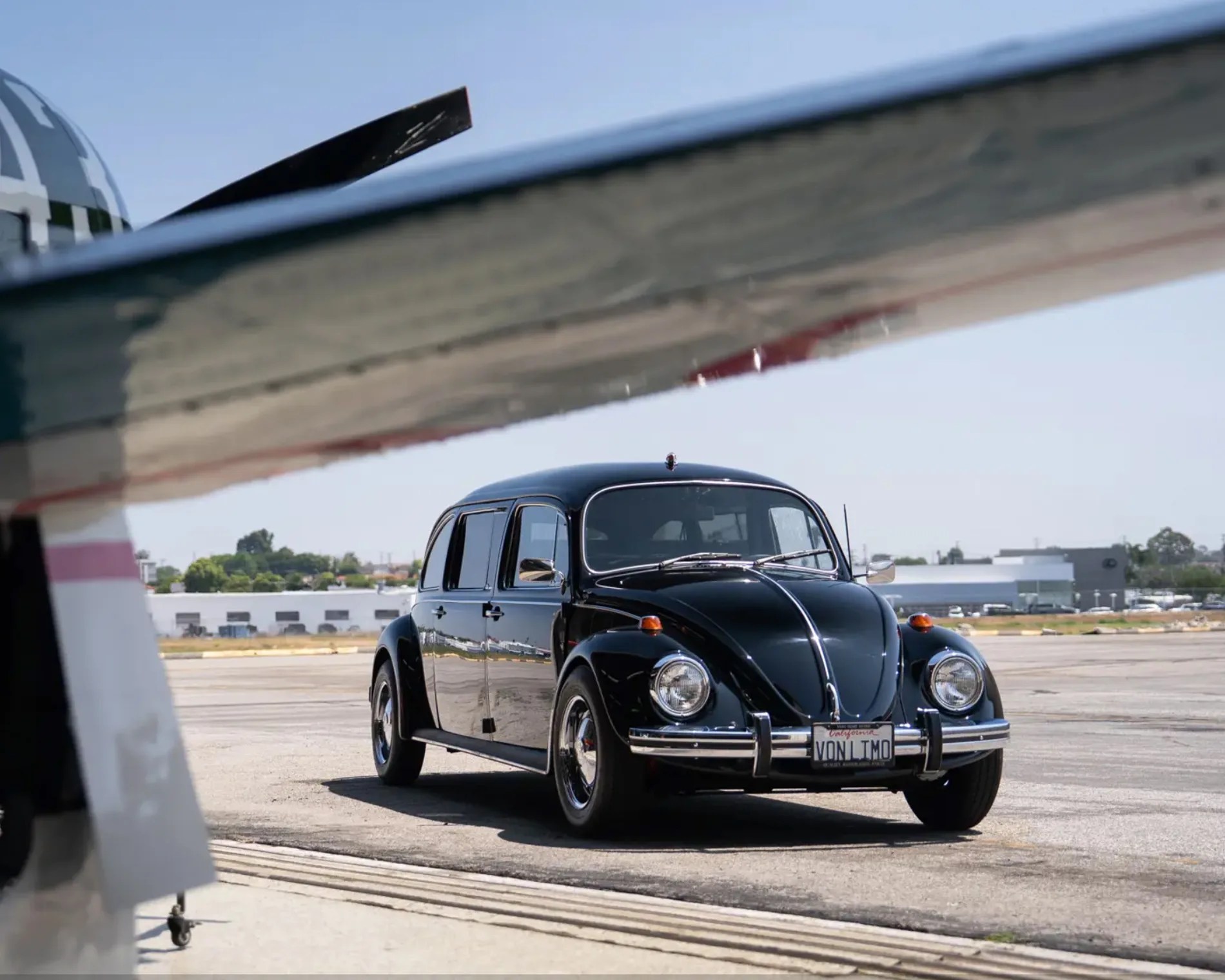 classic vw beetle under airplane wing