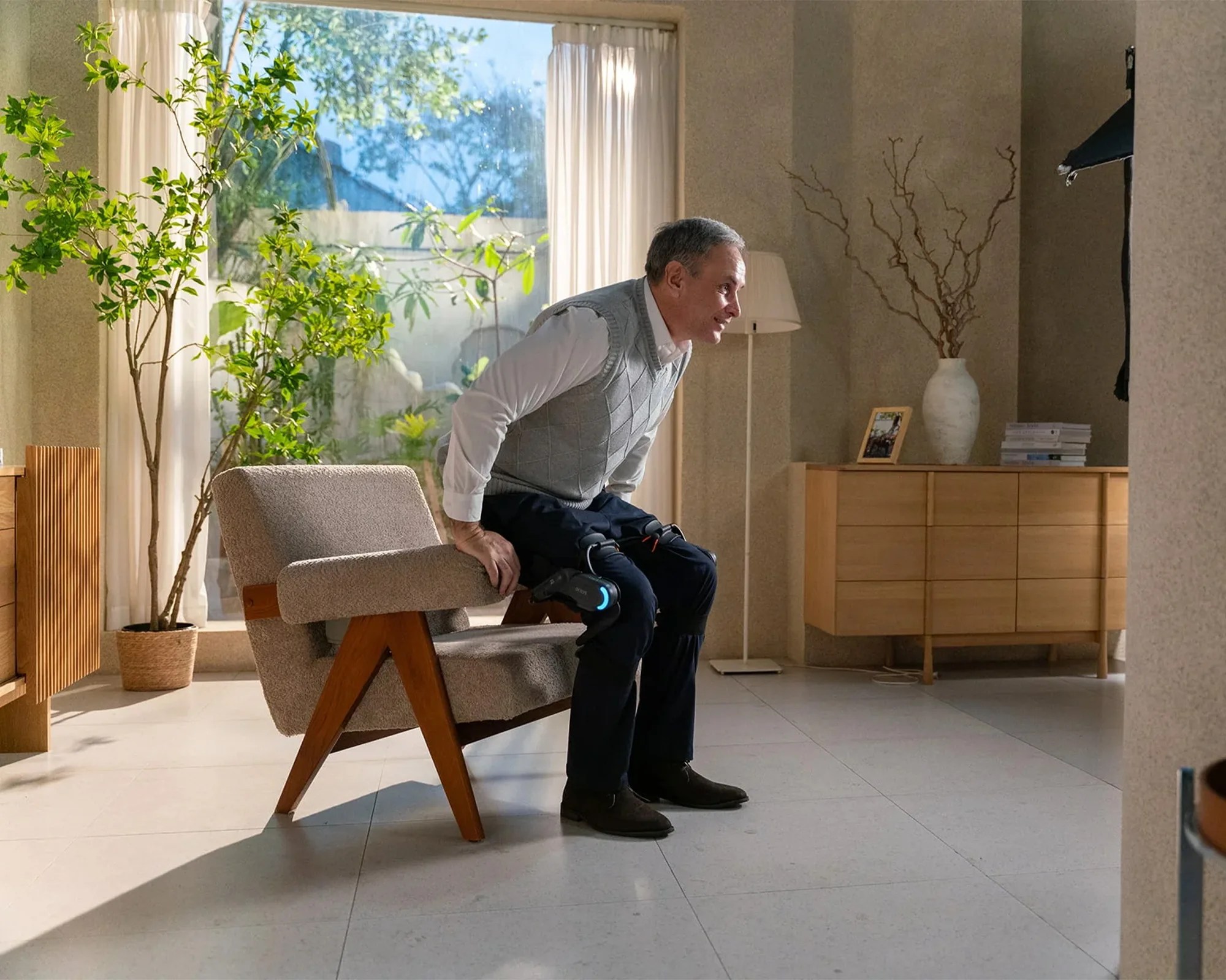 Dnsys Z1 Knee Exoskeleton on person getting out of midcentury modern chair in house