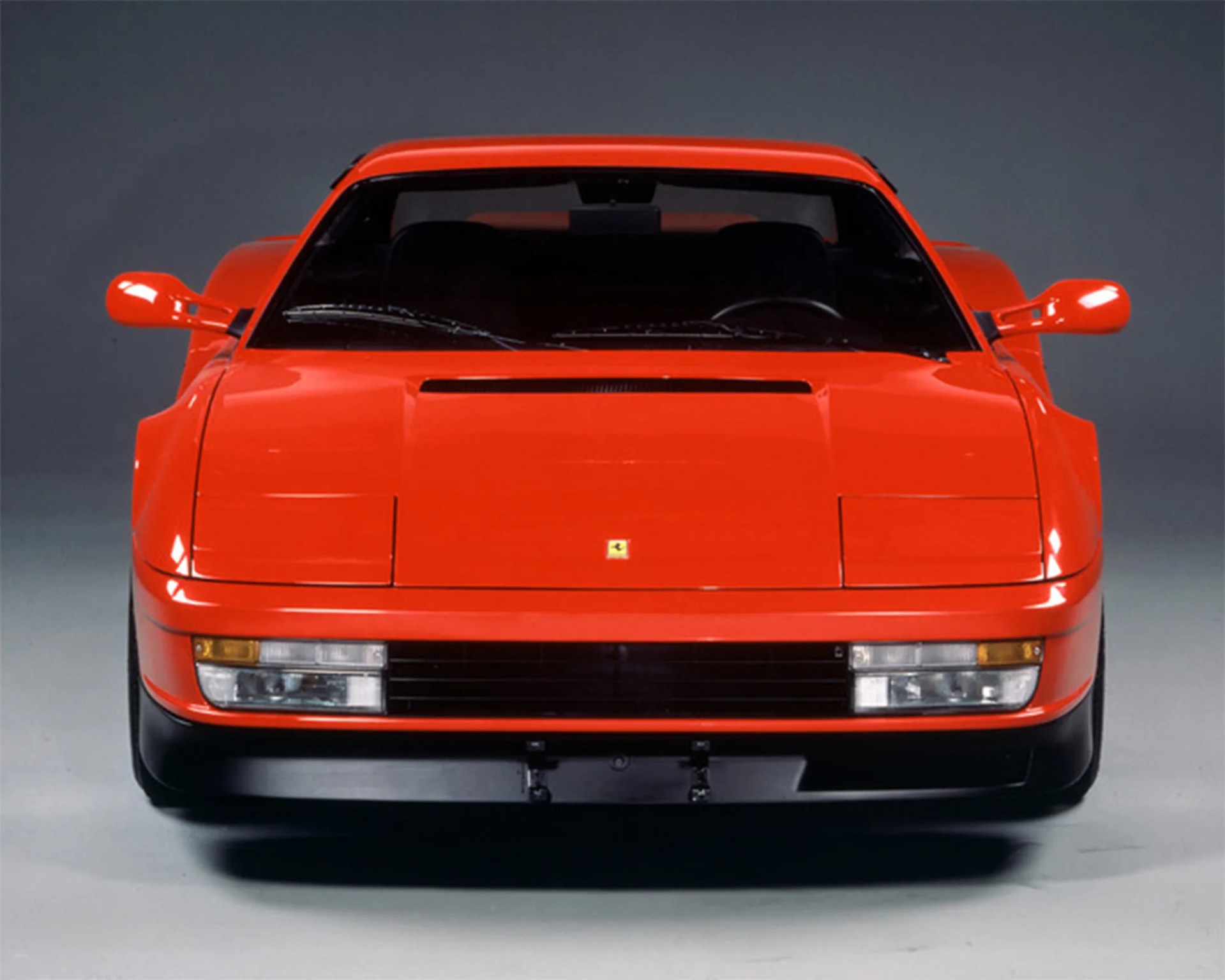 front on shot of red ferrari testarossa on studio backdrop