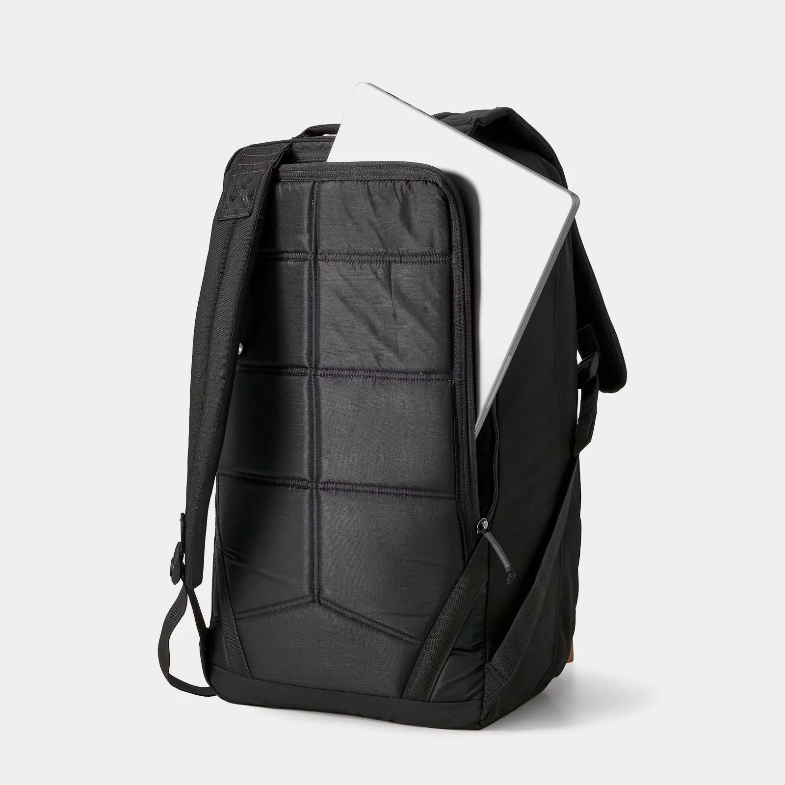 A silver laptop shown sliding into the back pocket of the Huckberry X GORUCK GR2 Slick Backpack - 40L