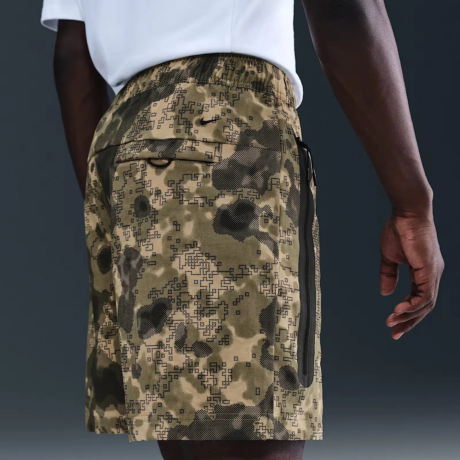 A male model wears a camo patterned Dri-Fit Windrunner shorts