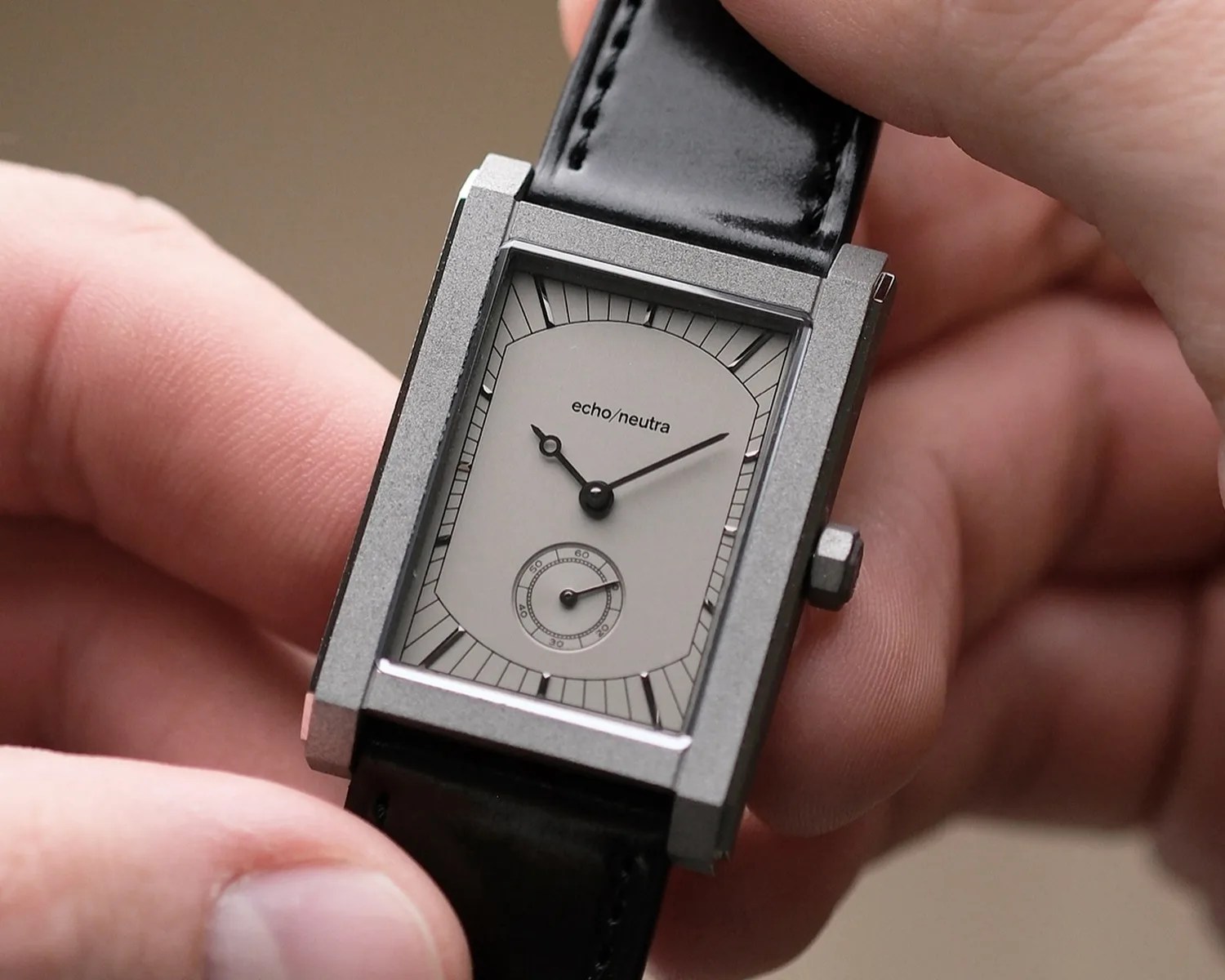 an echo neutra watch held in hands