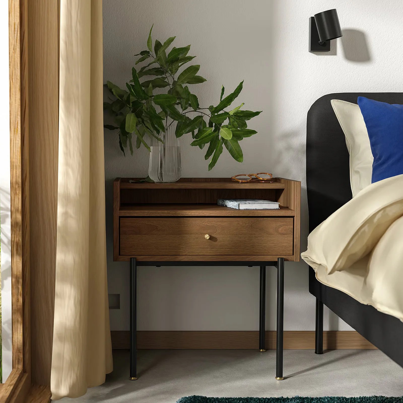 The IKEA RADMANSO nightstand is shown with a play on top sitting next to a made bed