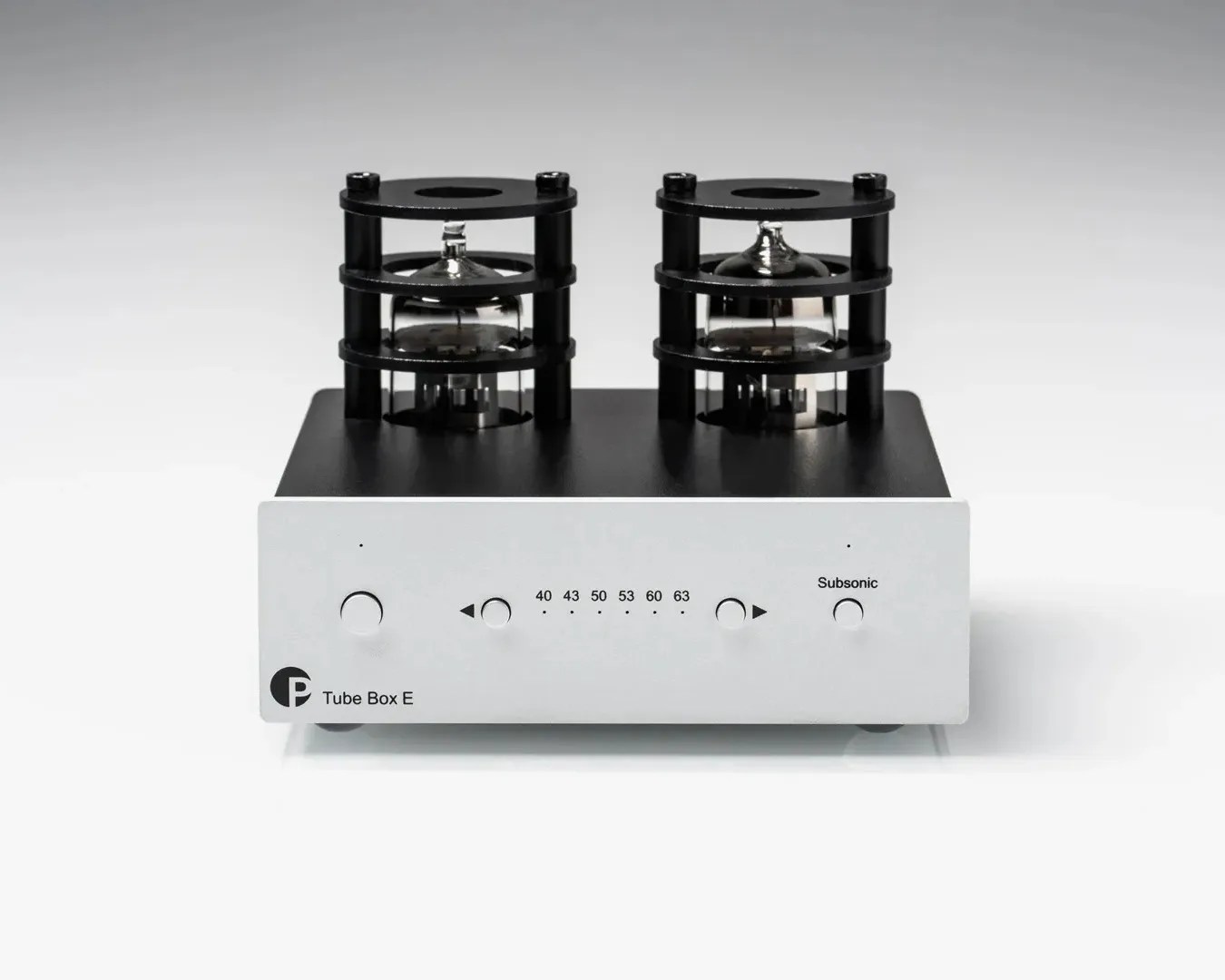 Compact tube amplifier with a silver front panel featuring five buttons and indicator lights for frequency settings (40, 43, 50, 53, 60, 63) and a "Subsonic" label. The top section is black with two large vacuum tubes protected by black circular cages. The bottom left corner of the front panel displays the label "Tube Box E" alongside a circular logo.