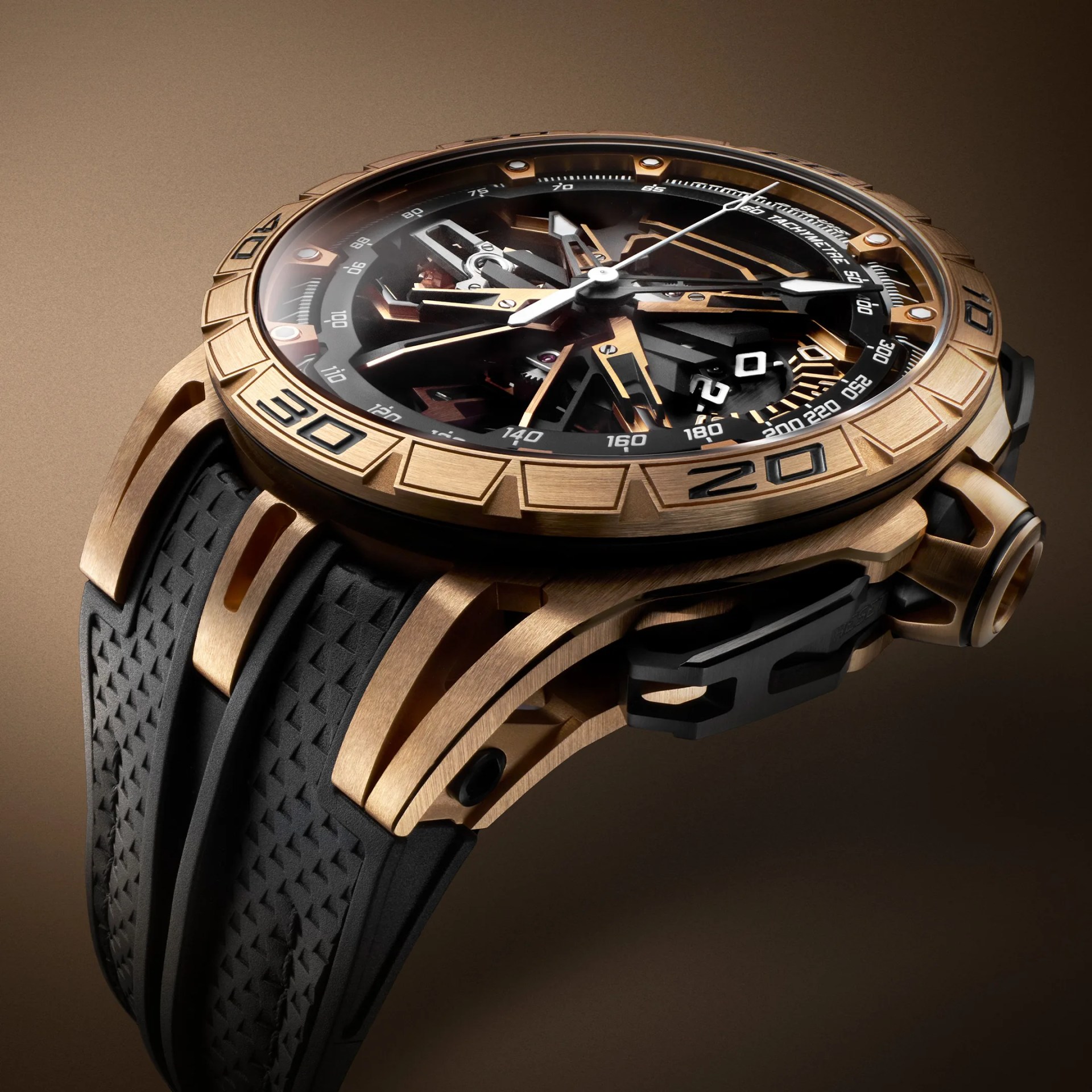 Luxury Roger Dubuis wristwatch with a rose gold case and a black textured rubber strap. The watch features a skeleton dial showcasing intricate mechanical components, with rose gold and black accents. The bezel has engraved numerals and markers, and the watch hands are silver with luminous tips. The overall design is modern and sophisticated.