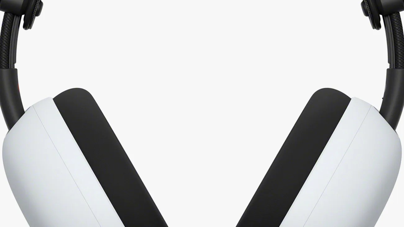 Close-up of white and black over-ear headphones showing the ear cups and part of the headband.