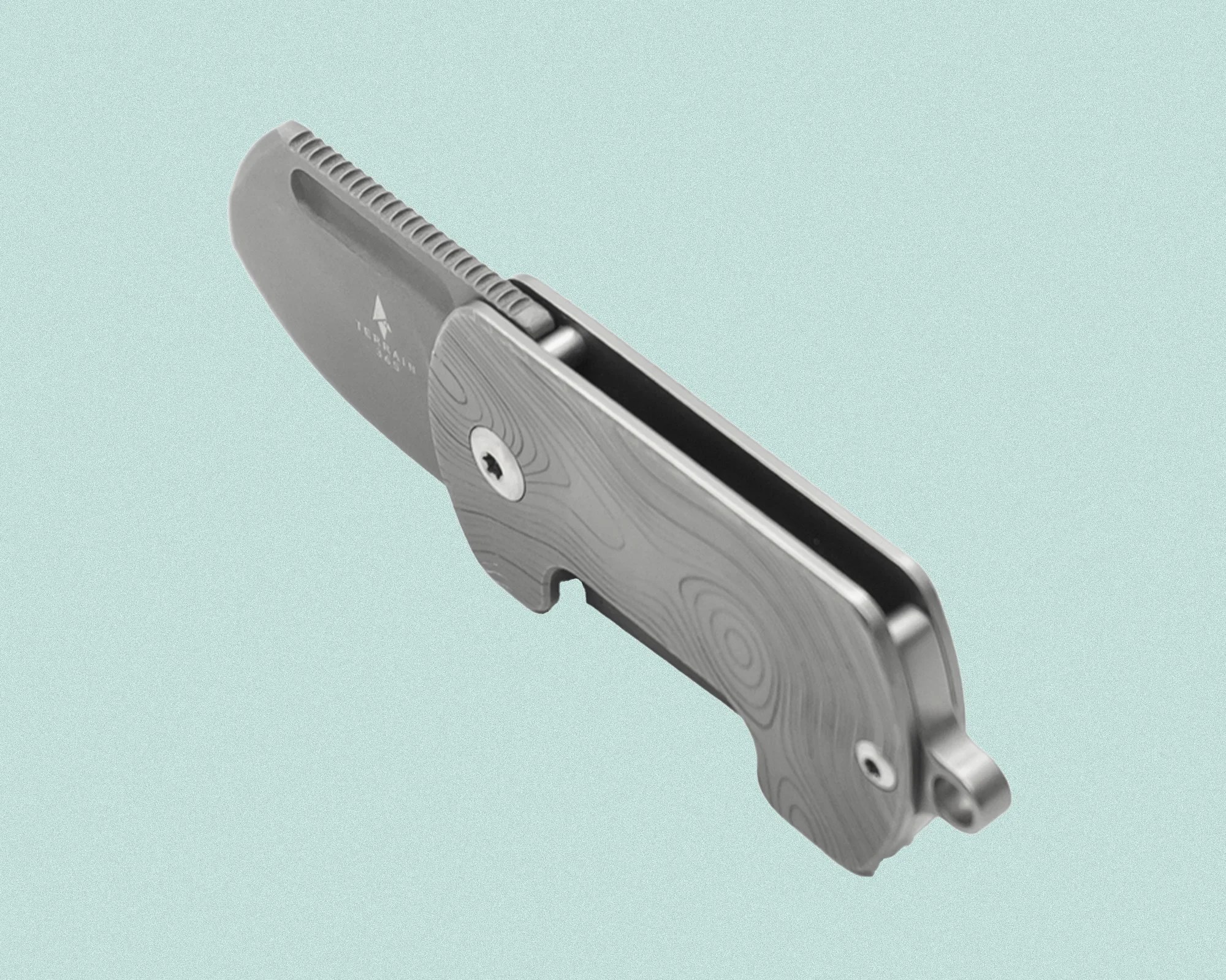 Compact folding knife with a small blade and a textured handle featuring a subtle wood grain pattern. The blade is matte gray with a thumb groove for easy opening, and the handle has a small loop at the end for attachment.