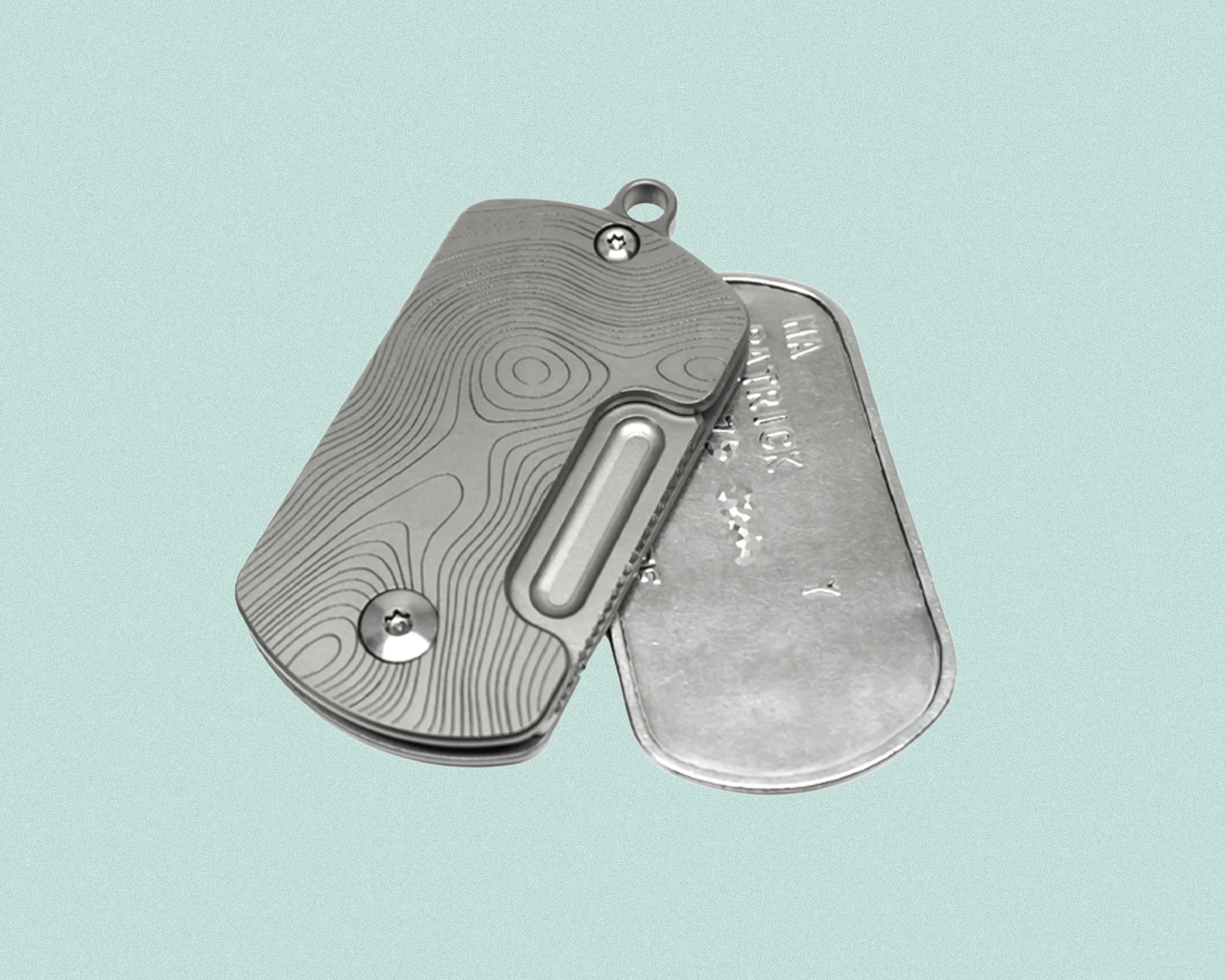 Two metal dog tags are shown, one with a smooth surface and engraved text, and the other with a textured surface featuring a topographic map design and two screws. The tags are overlapping on a light blue background.
