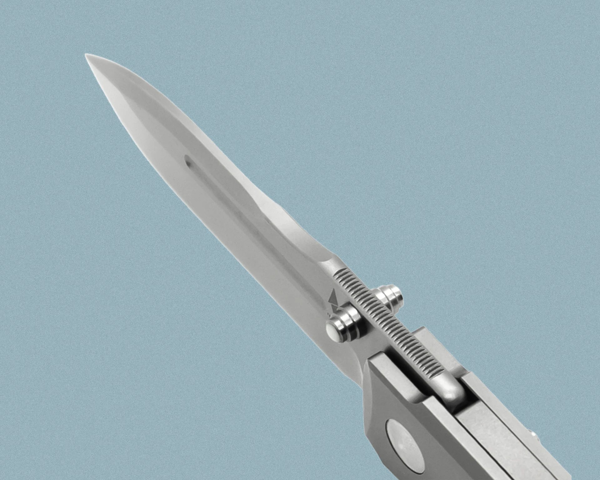 Close-up of a partially opened silver folding knife blade with a textured thumb stud and a liner lock mechanism, set against a plain light blue background.