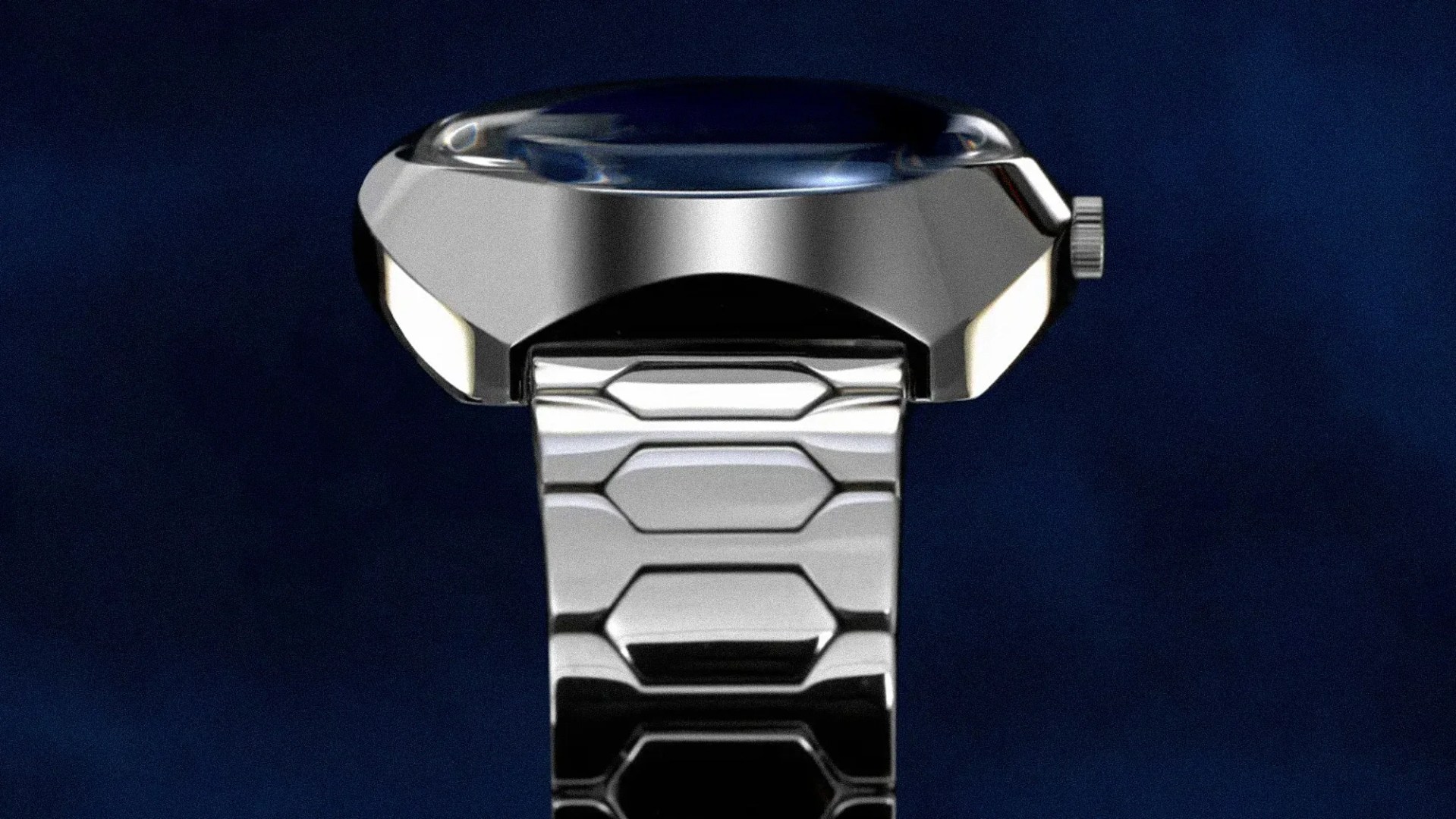 Close-up of a silver metallic wristwatch viewed from the side, showing the polished watch case, crown, and a portion of the linked bracelet against a dark blue background. The watch face is slightly domed with a reflective surface.