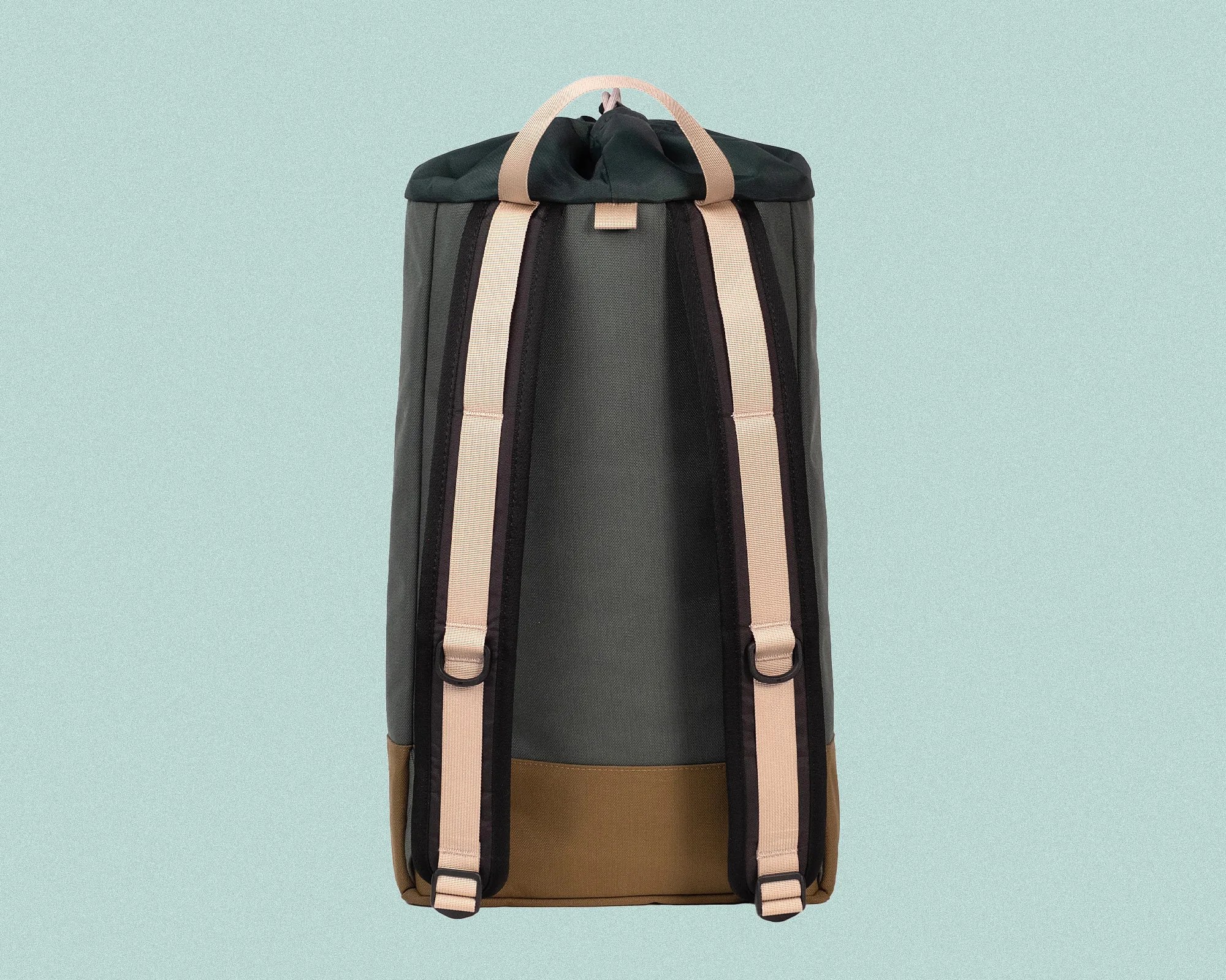 Back view of a backpack with dark green fabric, brown bottom, and light beige adjustable shoulder straps with black edges. The backpack has a top handle in the same beige color as the straps.