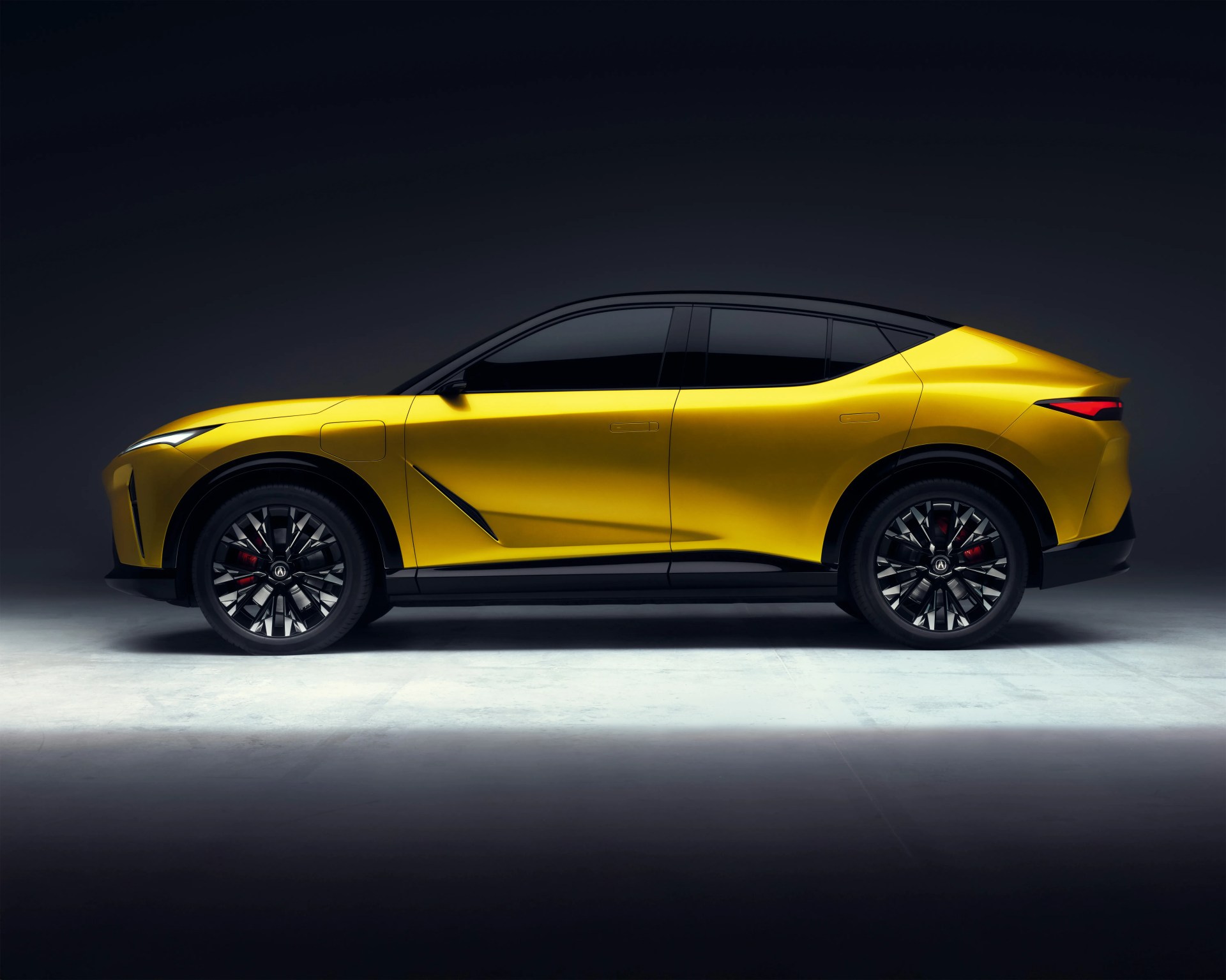 Sleek yellow electric SUV with a black roof and tinted windows, featuring sharp angular lines and modern design elements. The vehicle has large black alloy wheels with intricate spoke patterns and red brake calipers, set against a dark gradient background.