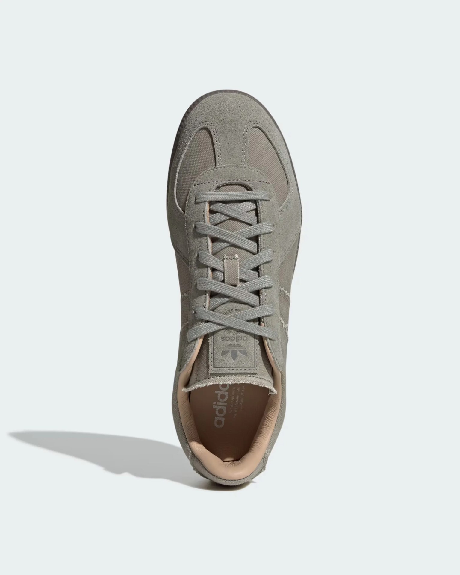 Gray suede and mesh sneaker with matching gray laces, a padded beige collar, and an Adidas logo on the tongue and insole.