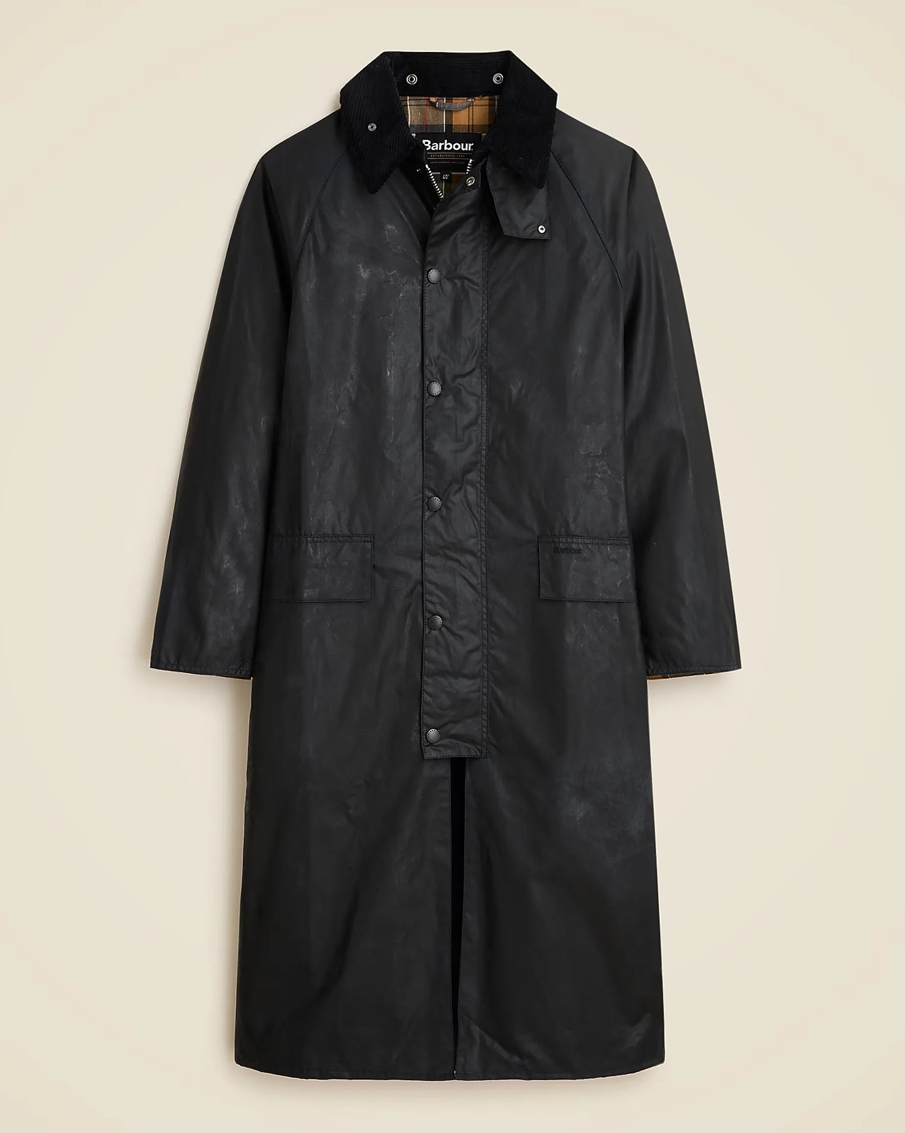 Black long waxed cotton coat with a corduroy collar, front snap buttons, and two front flap pockets. The interior features a classic tartan lining.