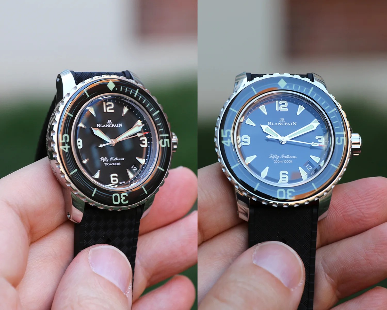 Two Blancpain Fifty Fathoms wristwatches with black dials and black textured rubber straps, each held between a thumb and fingers. Both watches feature luminous hour markers, a rotating bezel with minute markers, and a date window at the 4:30 position. The left watch has a slightly darker dial and bezel, while the right watch's dial and bezel appear lighter with a blue tint. Both watches indicate water resistance of 300m/1000ft.