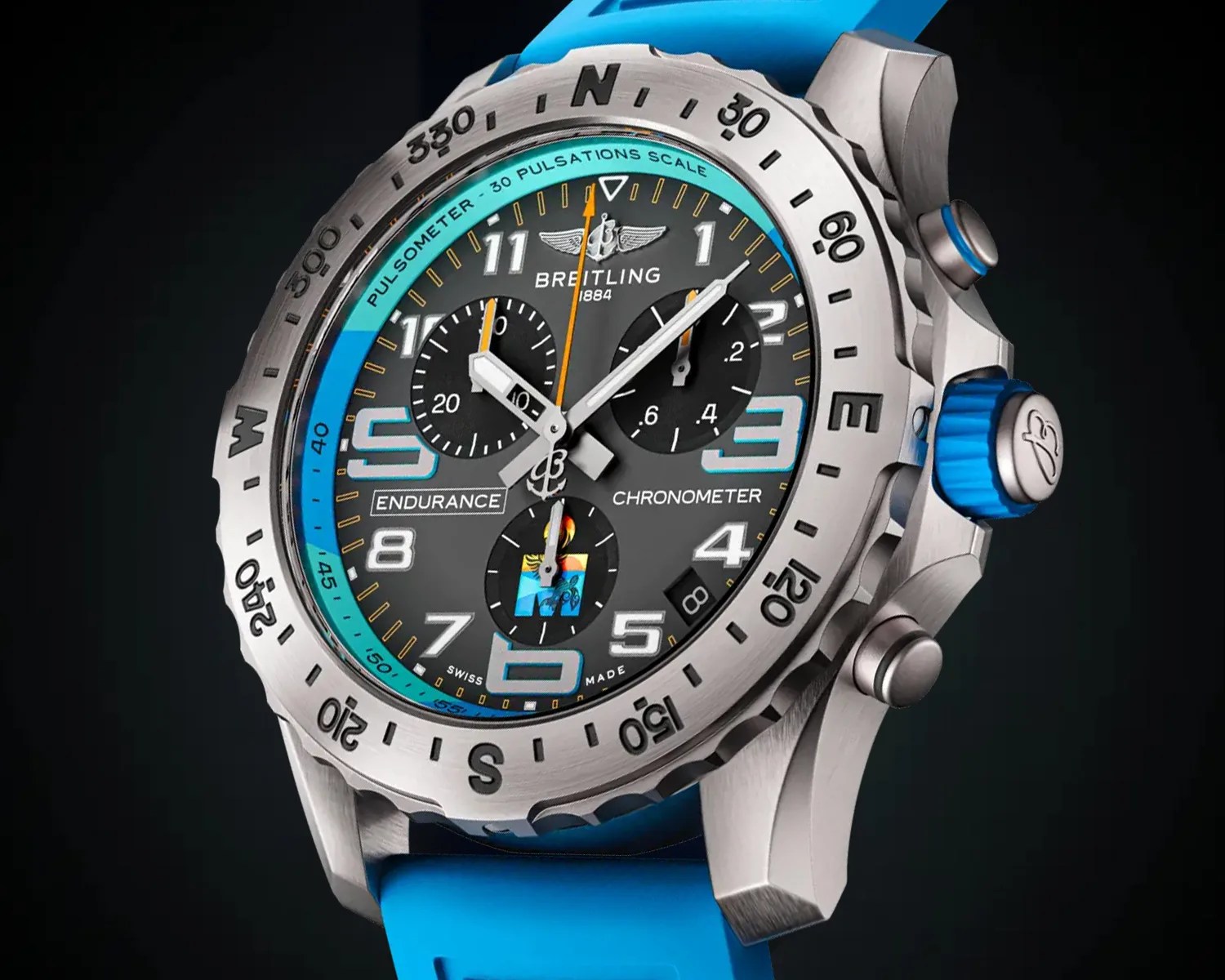 Breitling Endurance chronometer watch with a titanium case, black dial, and blue accents. It features three subdials, large numerals at 3, 6, 9, and 12, and a date window between 4 and 5 o'clock. The bezel has compass markings (N, E, S, W) and a pulsometer scale. The watch has a blue rubber strap and a blue crown with the Breitling logo.