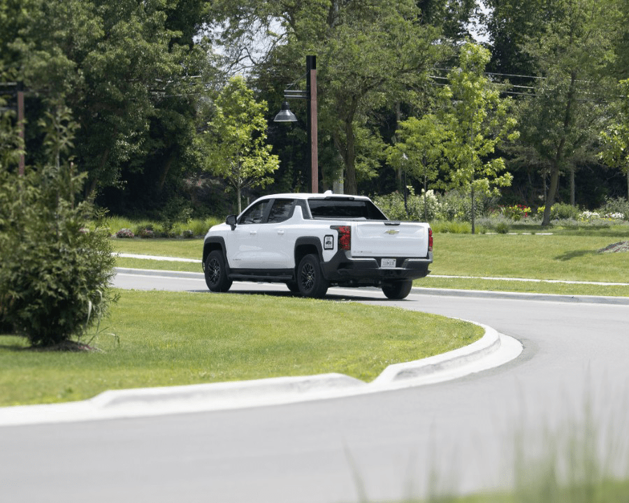 a photo of an electric chevrolet pickup truck driving around a turn