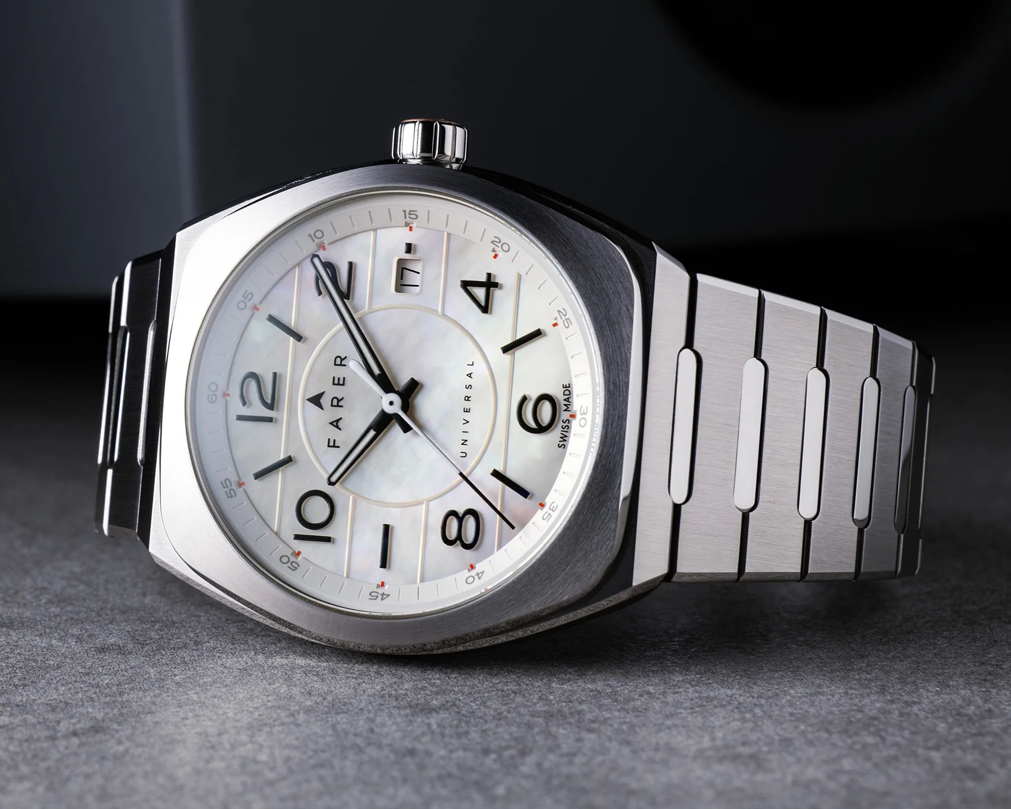 Silver stainless steel wristwatch with a white mother-of-pearl dial featuring black Arabic numerals, black hour and minute hands, a date window at 3 o'clock, and a second hand. The watch has a brushed metal case and a matching metal link bracelet. The brand name "FARER" and "UNIVERSAL" are printed on the dial, along with "SWISS MADE" near the 6 o'clock position.