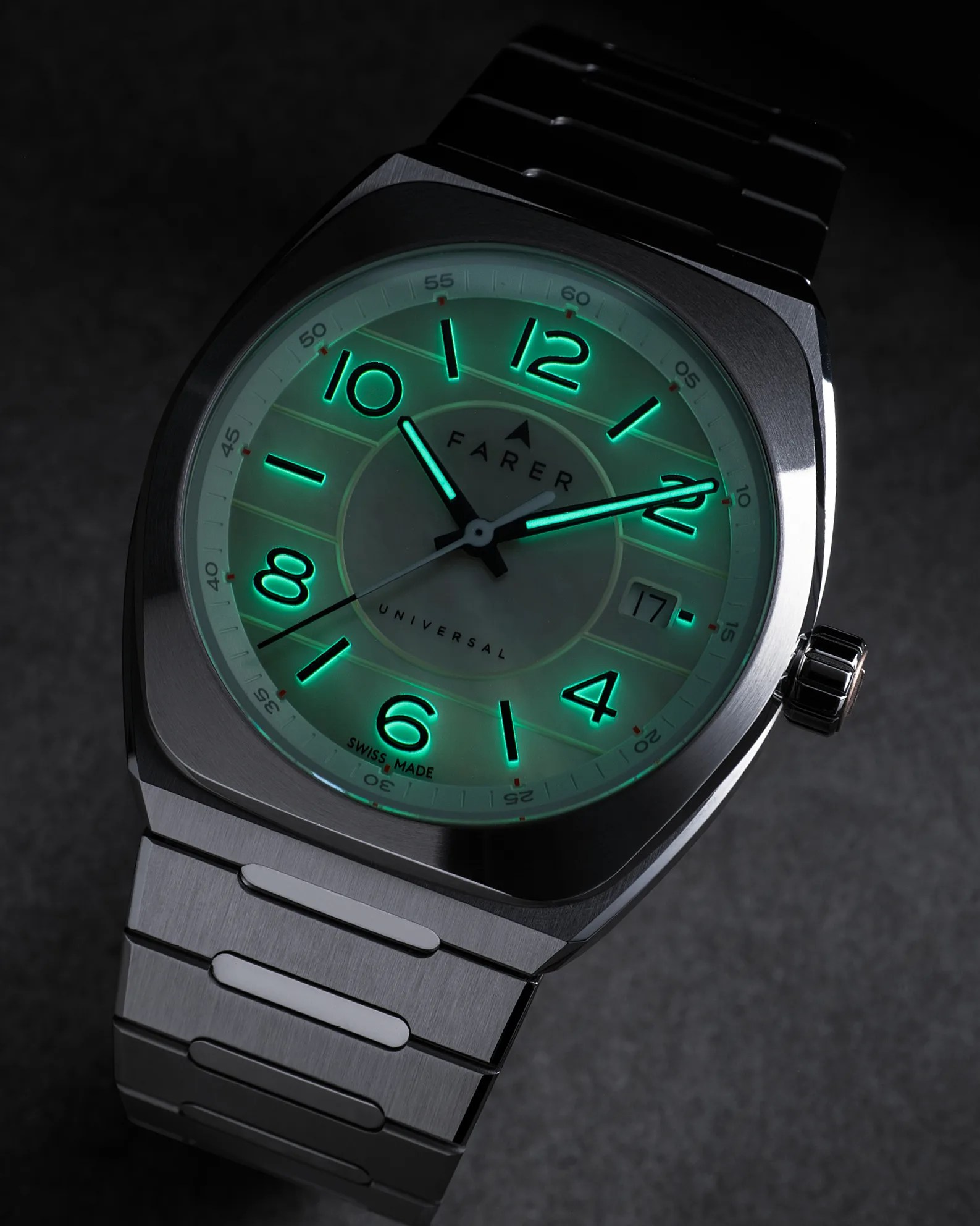Stainless steel wristwatch with a square case and integrated bracelet. The dial features large, glowing green Arabic numerals and hands, with a date window at the 3 o'clock position. The brand name "FARER" and the word "UNIVERSAL" are visible on the dial, along with "SWISS MADE" at the bottom. The watch is shown in low light, highlighting the luminescent elements.