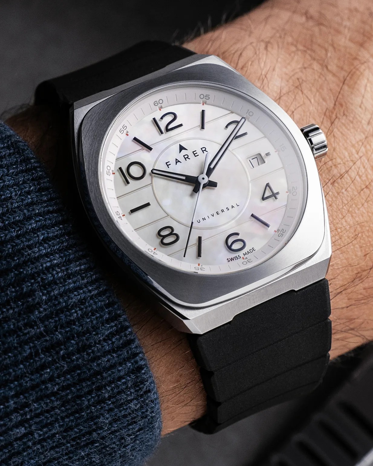 Square stainless steel wristwatch with a white mother-of-pearl dial, black Arabic numerals, and black hour and minute hands. The watch has a black second hand and a date window at the 3 o'clock position. The brand name "FARER" and the word "UNIVERSAL" are printed on the dial, along with "SWISS MADE" near the 6 o'clock position. The watch is secured with a black rubber strap.