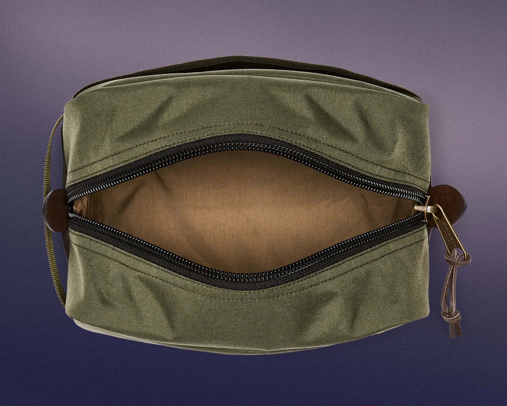 Olive green rectangular fabric pouch with a black zipper partially open, revealing a brown interior lining. The zipper has a brass pull tab with a leather loop attached. The pouch has a small fabric loop on one side.