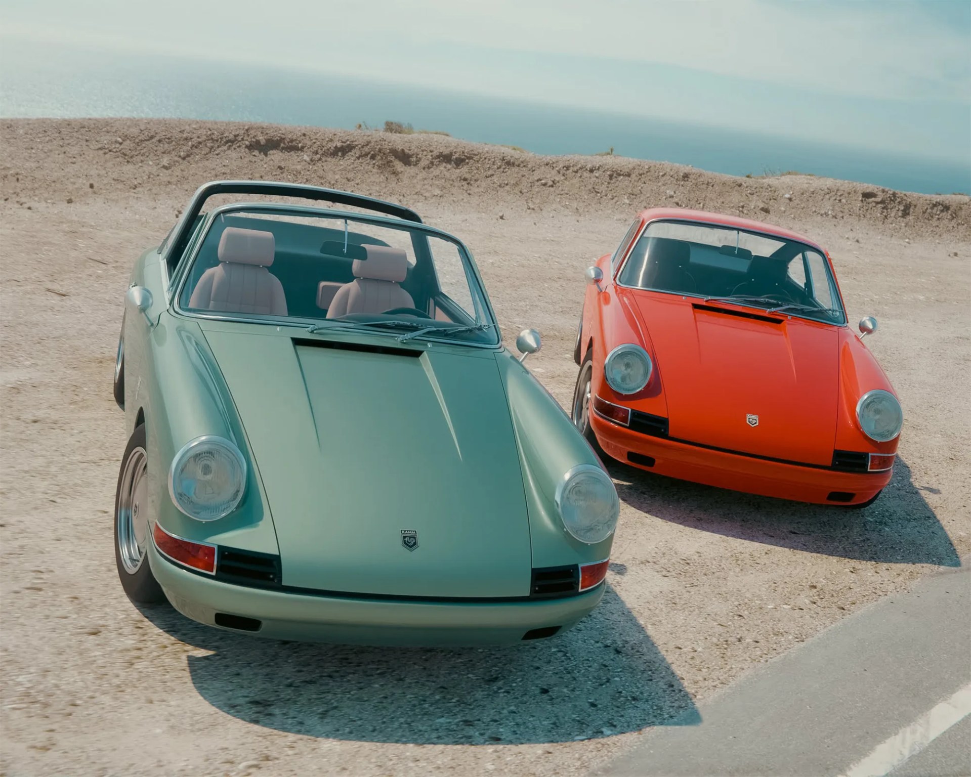 a photo of two classic porsche 912 restoration cars on a coastal overlook