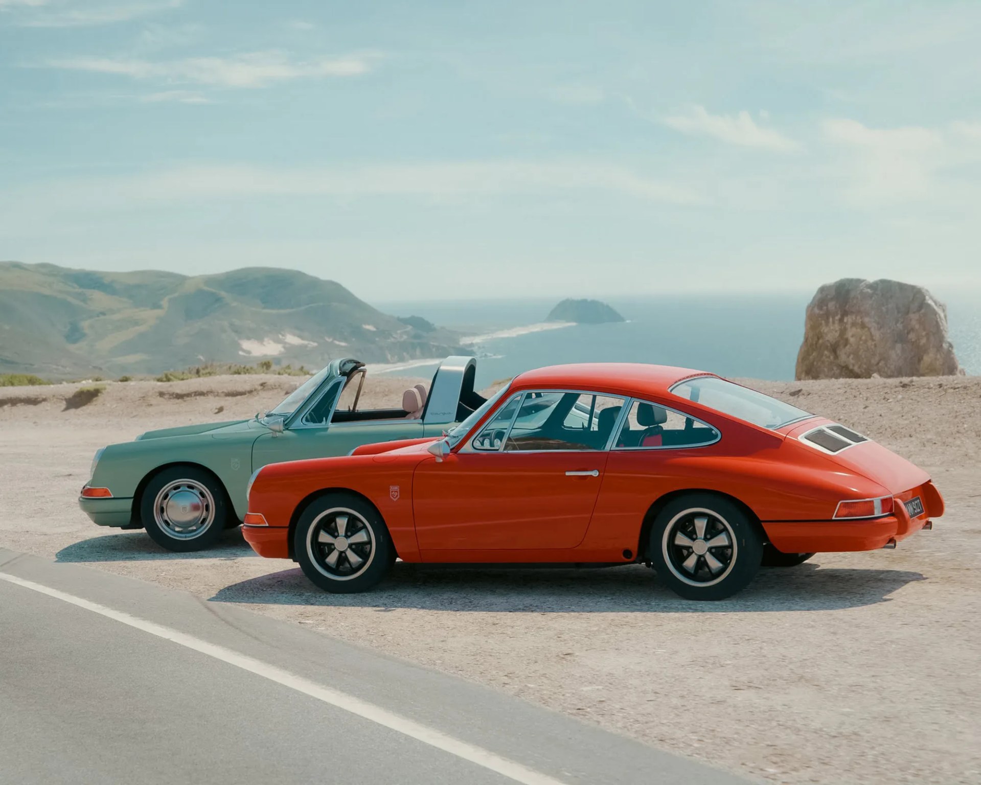 a photo of two classic porsche 912 restoration cars on a coastal overlook
