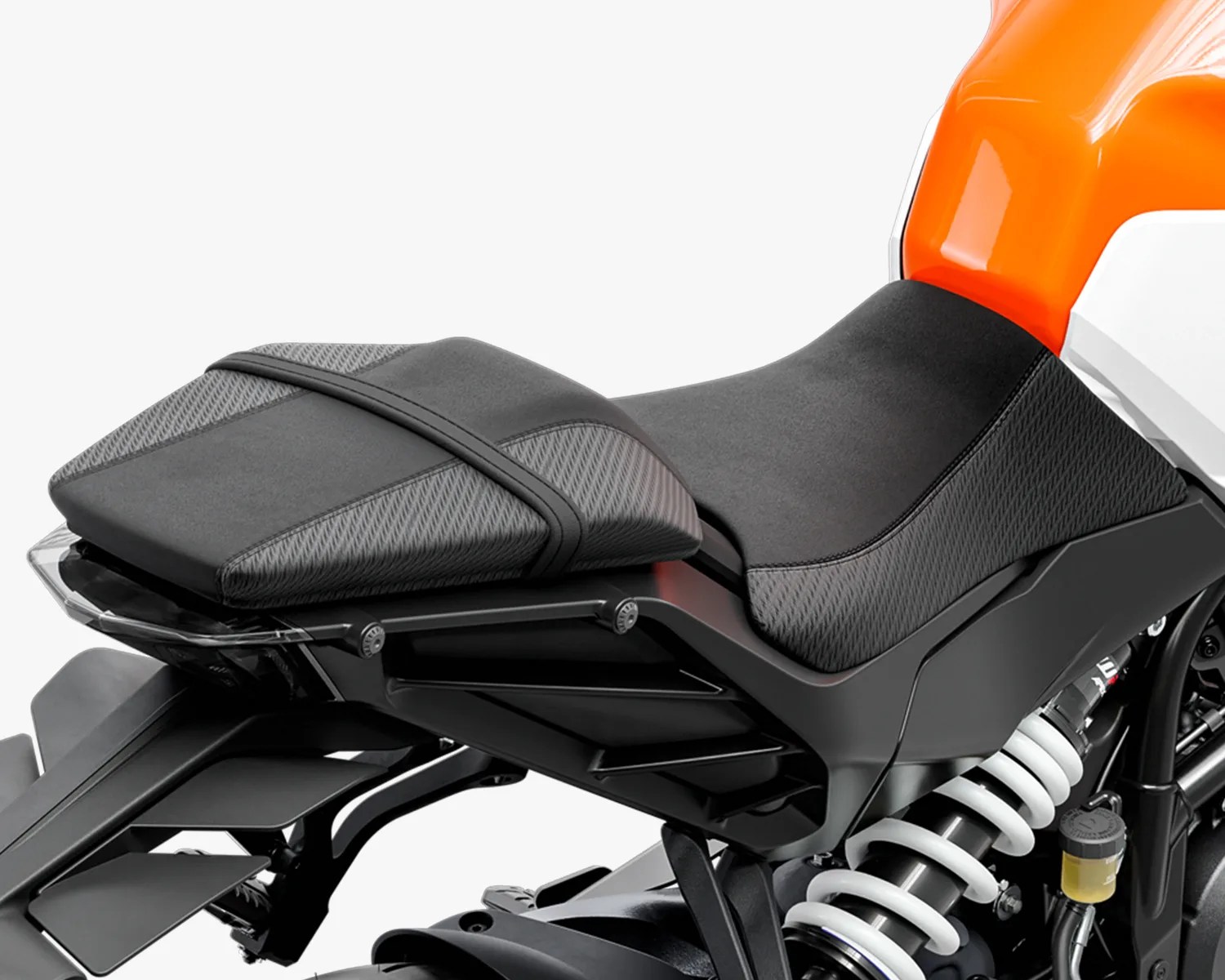 Motorcycle seat with a two-tone design featuring textured gray and smooth black sections, secured with a black strap. The seat is mounted on a black frame with visible suspension components and an orange and white body panel above.