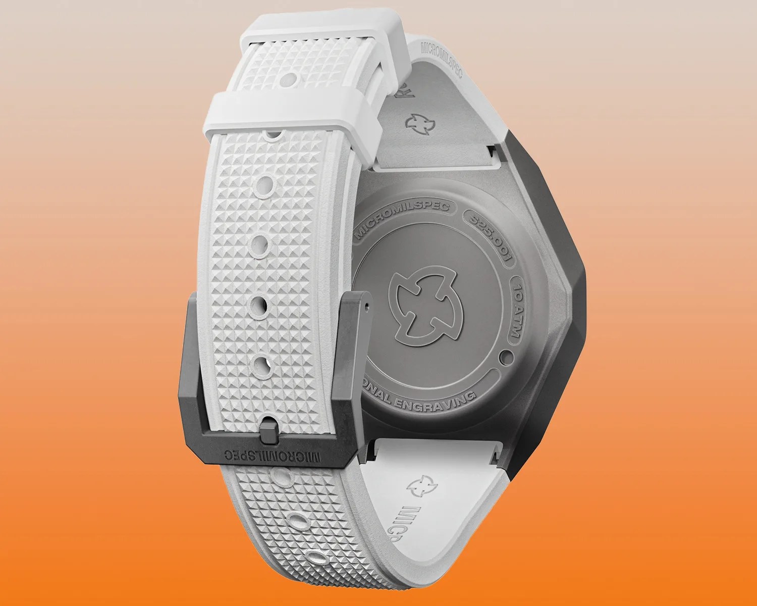 White textured watch strap with multiple adjustment holes and a black buckle labeled "MICROMILSPEC." The back of the watch case is visible, featuring an engraved logo in the center and text around the edge that reads "MICROMILSPEC," "S25.001," "10 ATM," and "PERSONAL ENGRAVING." The background is a gradient from light beige at the top to orange at the bottom.