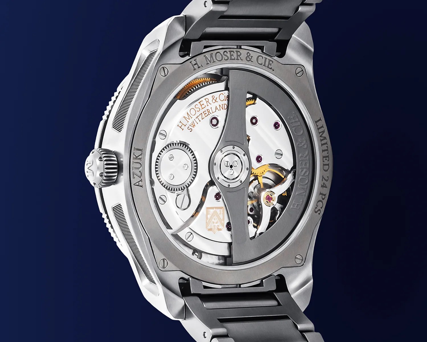 Close-up of the back of a luxury moser wristwatch showcasing its intricate mechanical movement. The watch features a titanium case and bracelet, with visible gears and components inside. Engraved on the case back are the inscriptions "H. MOSER & CIE.," "LIMITED 24 PCS," and "AZUKI." The movement is marked "H. MOSER & CIE SWITZERLAND," highlighting its Swiss craftsmanship. The design emphasizes precision engineering and high-quality materials.
