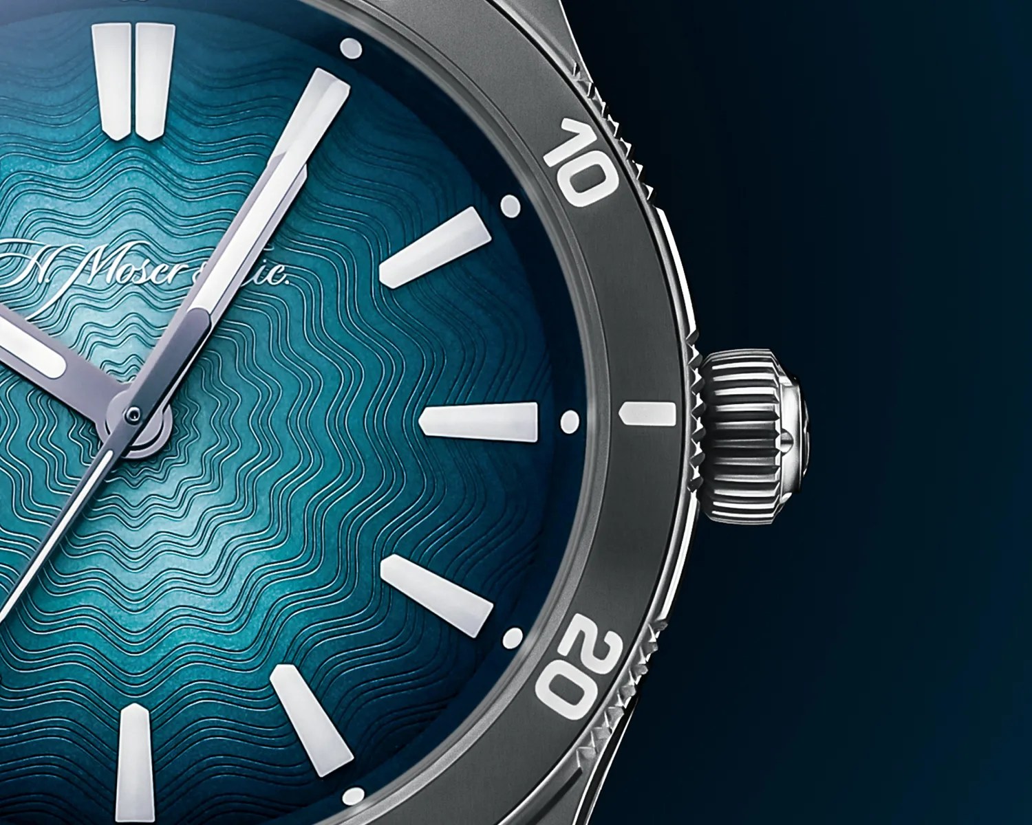Close-up of a luxury watch face with a textured blue dial featuring wavy patterns. The watch has silver hour markers and hands, with a rotating bezel marked with numbers 10 and 20. The crown is visible on the right side, and the brand name "H. Moser & Cie." is partially visible on the dial.