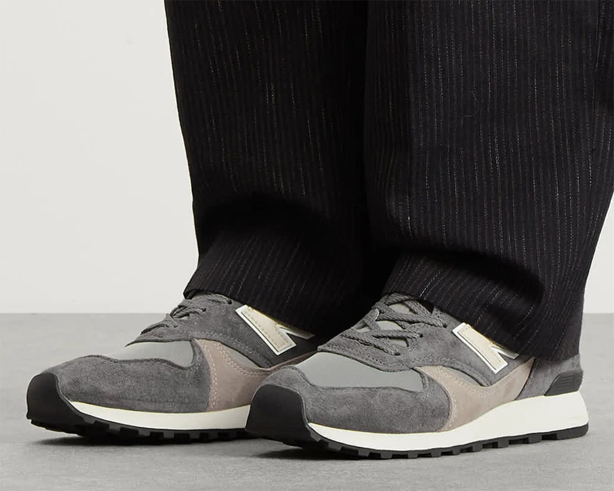 a man wearing gray new balance sneakers