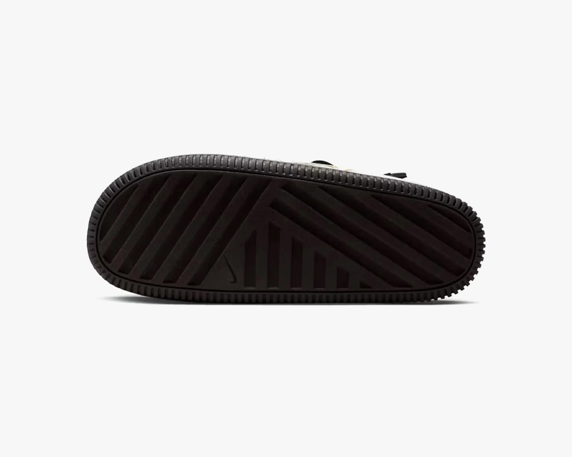 Black rubber sole of a shoe with a pattern of diagonal and vertical grooves for traction. The sole has a textured edge around its perimeter.
