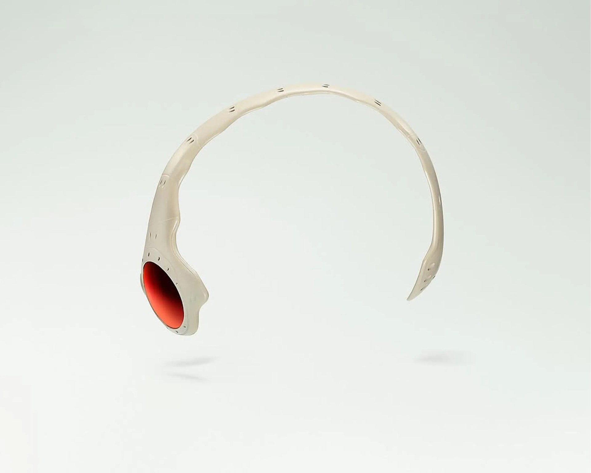 Beige, futuristic-style sunglasses with a single red-tinted lens on one side and an open frame design. The frame has a smooth, sculpted appearance with small cut-out details along the top and sides.