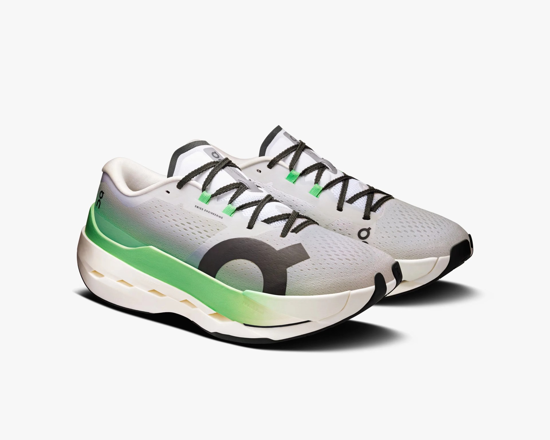 Pair of white and light gray running shoes with black laces, featuring a green gradient midsole and black accents, including a large black logo on the side. The shoes have a breathable mesh upper and a thick, cushioned sole designed for comfort and performance.