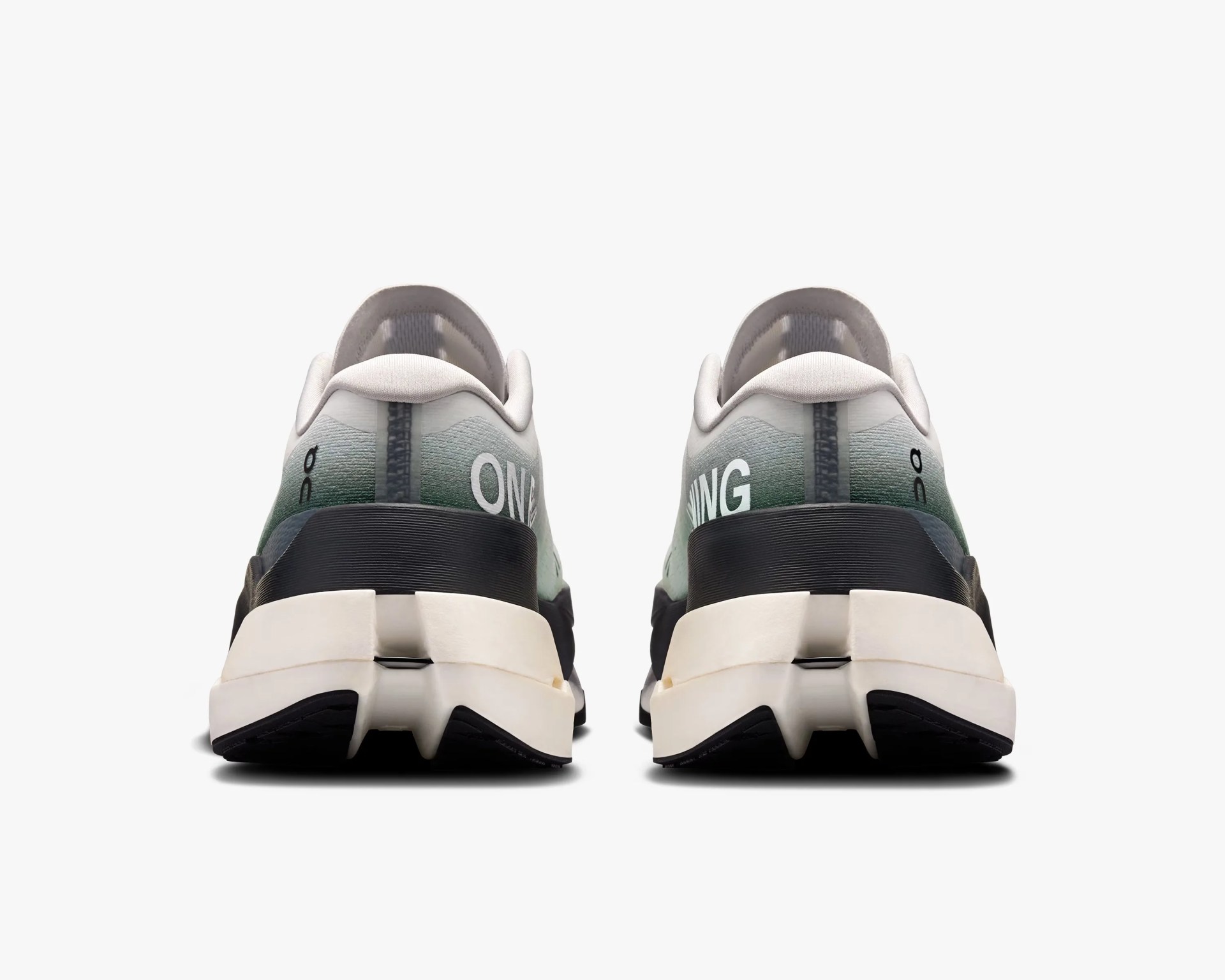 Pair of athletic shoes shown from the back, featuring a gradient upper transitioning from light gray at the top to green towards the bottom. The shoes have a thick white midsole with a black section wrapping around the heel. The outsole is black with a distinctive split design in the center. The text "ON" is visible on the left shoe and "RUNNING" on the right shoe, both in white. The shoes have a low-cut collar with light gray padding.