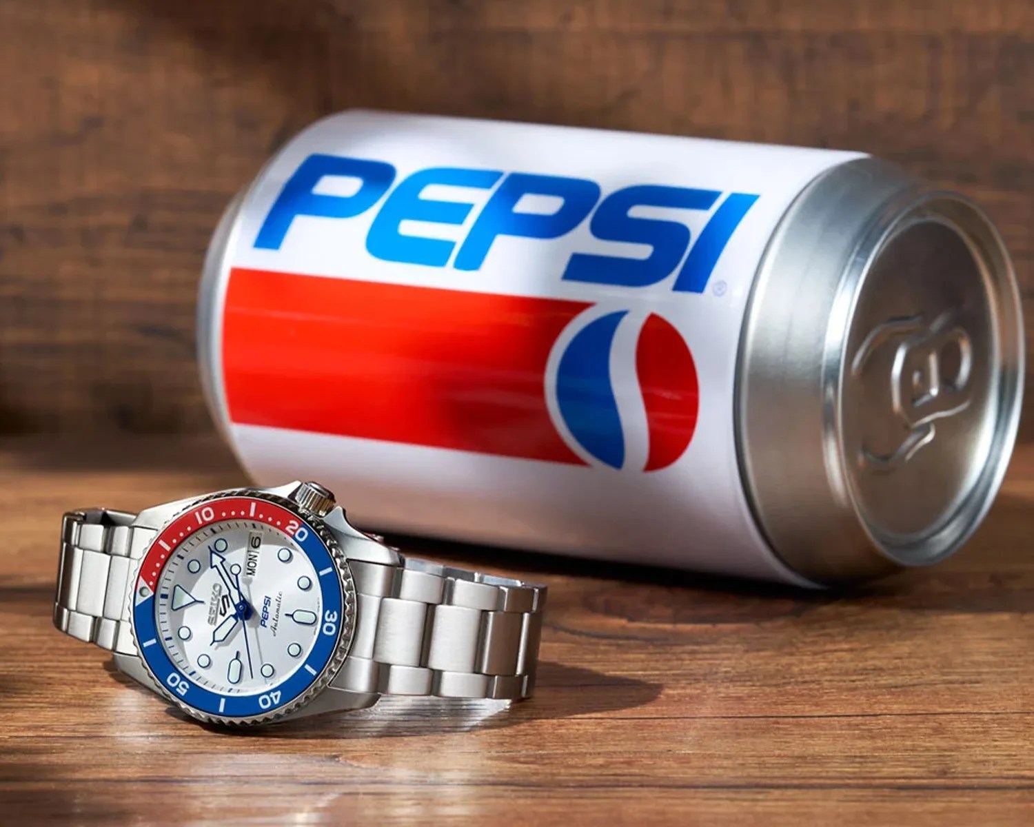 a seiko watch next to a pepsi can