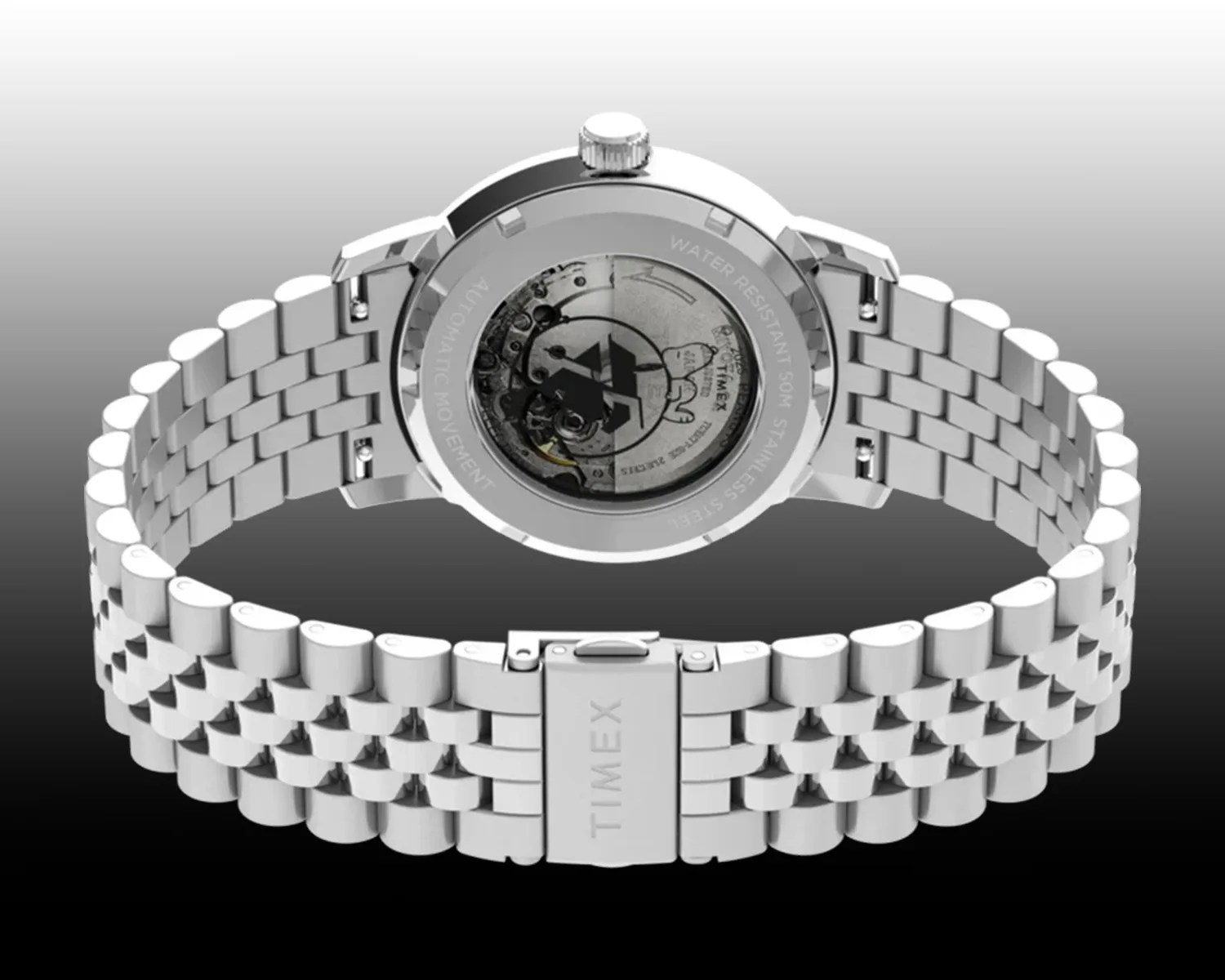 Silver stainless steel Timex wristwatch with a metal link bracelet, shown from the back. The watch features a transparent case back revealing the automatic movement inside. The clasp is engraved with the Timex logo. The watch is water resistant up to 50 meters.